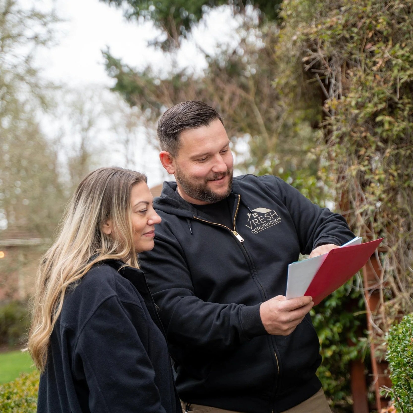Contractor discussing gutter replacement options with homeowner outside Portland property, highlighting seamless aluminum systems, fascia protection, and drainage planning.