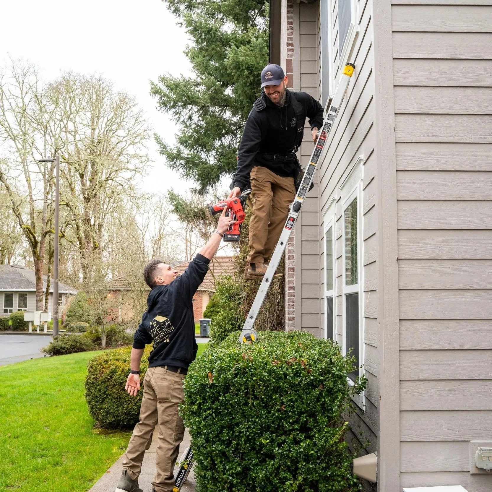 Roofing crew using ladder to access roof, representing evaluation of shingle options like CertainTeed and Owens Corning based on climate and durability needs.