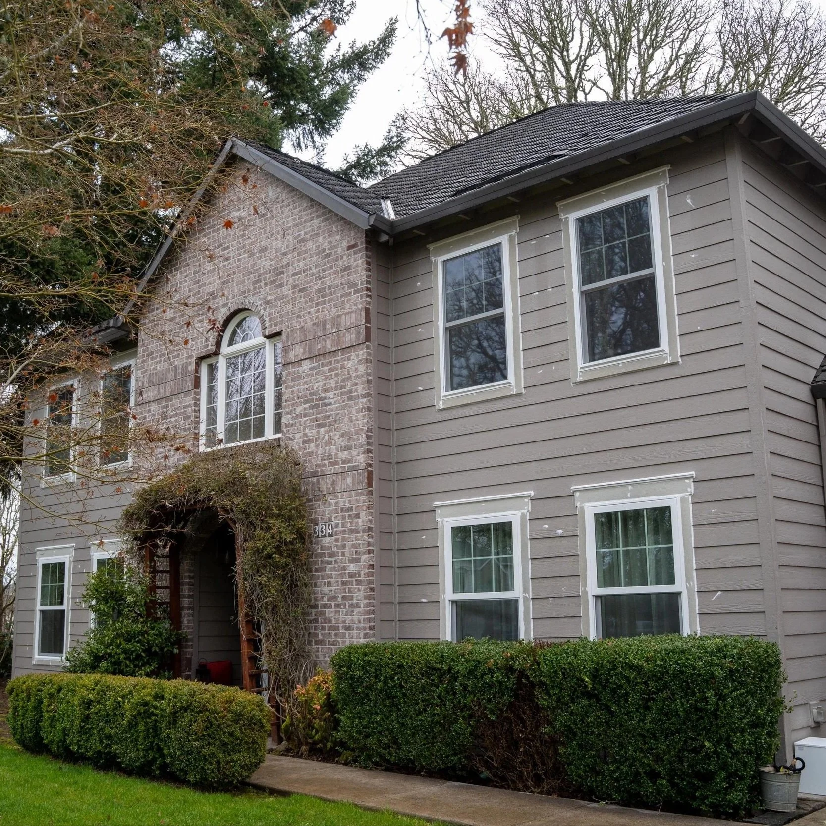 Two-story house with light siding exterior showing typical residential installation, relevant to comparing vinyl and Hardie siding durability in wet climates like Portland.