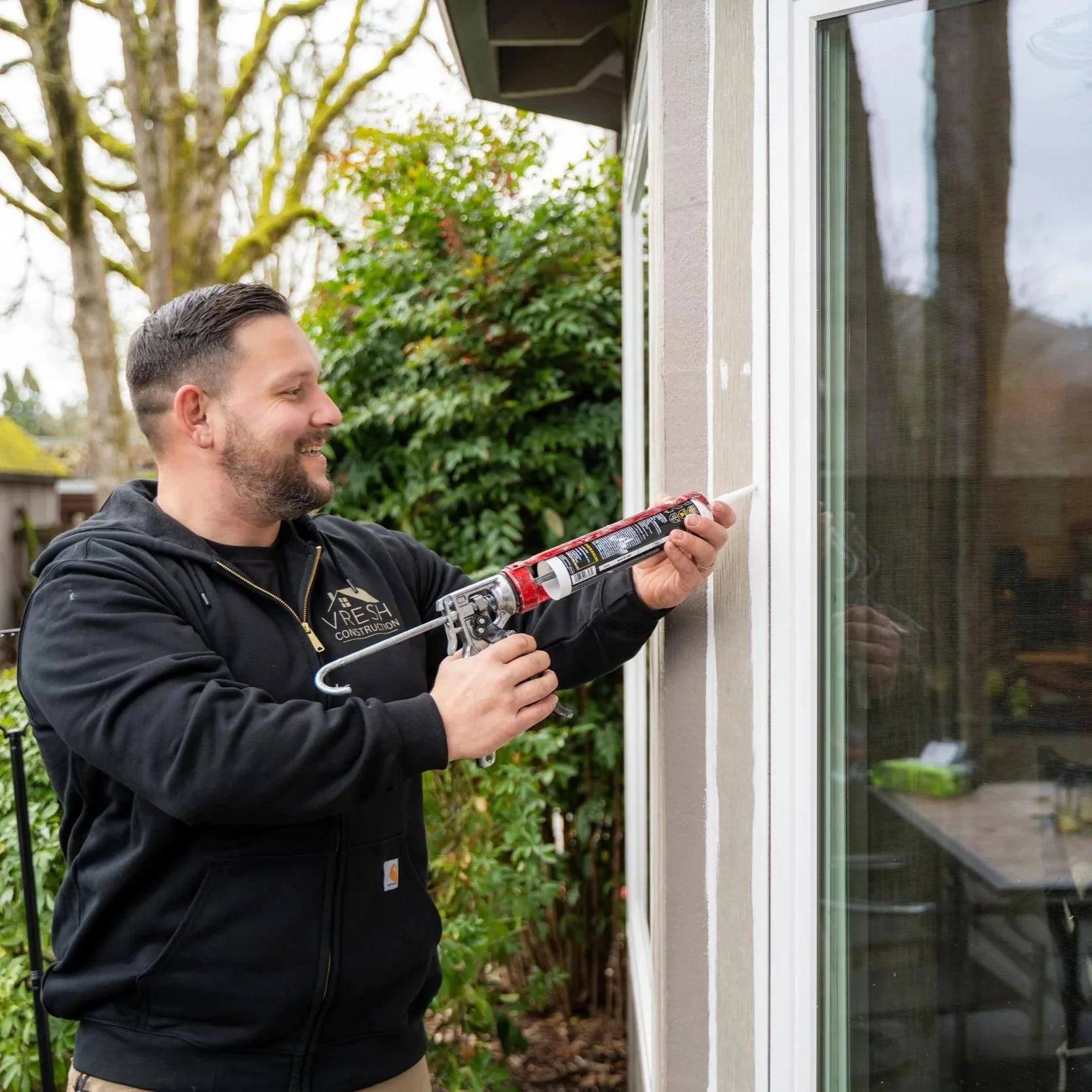 Contractor using power tool on window frame, illustrating window installation process and importance of choosing between Milgard and Marvin for performance and cost.