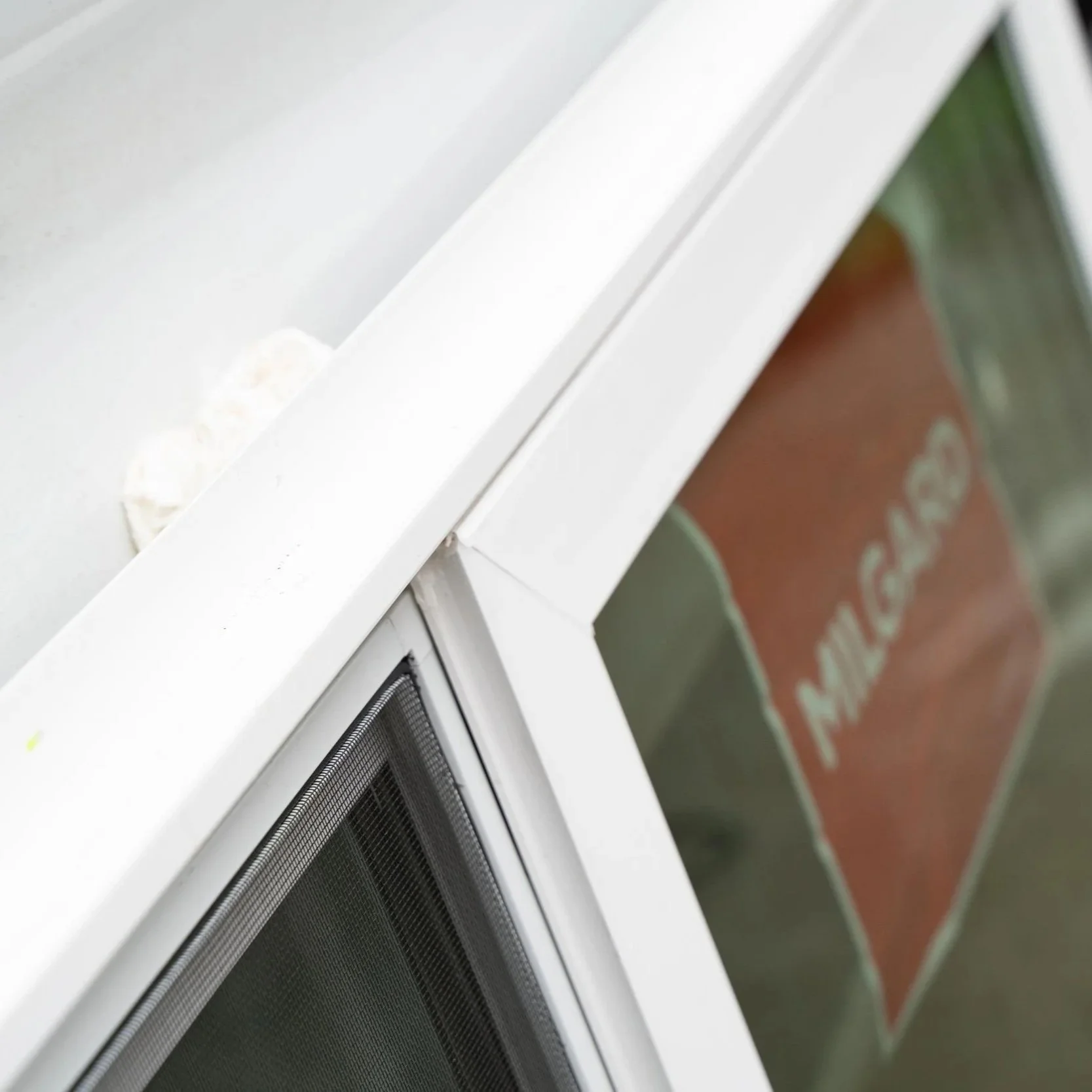 Close-up of white kitchen window frame and glass panel, showing clean trim and finish typical of minor remodel upgrades improving resale appeal.