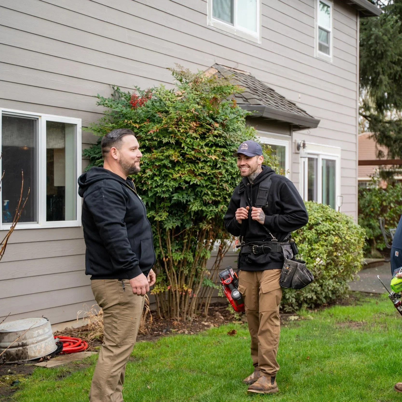 Group of contractors inspecting home exterior, representing evaluation process for deciding between roof repair or full replacement based on damage and condition.
