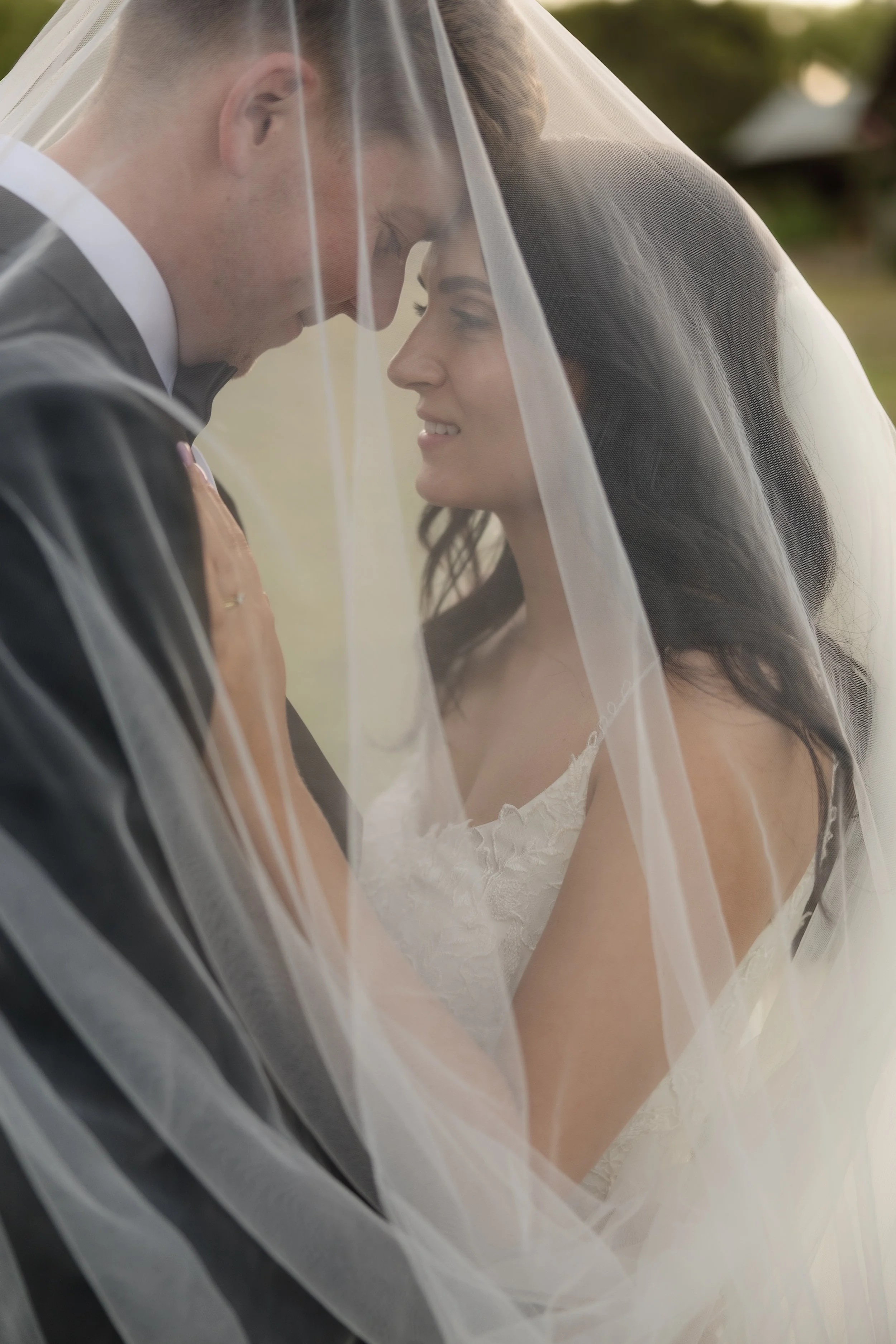 Romantic under-the-veil portrait of bride and groom at golden hour during a Hahndorf wedding in the Adelaide Hills — intimate couples photo with soft light filtering through the bridal veil, bride in lace wedding gown