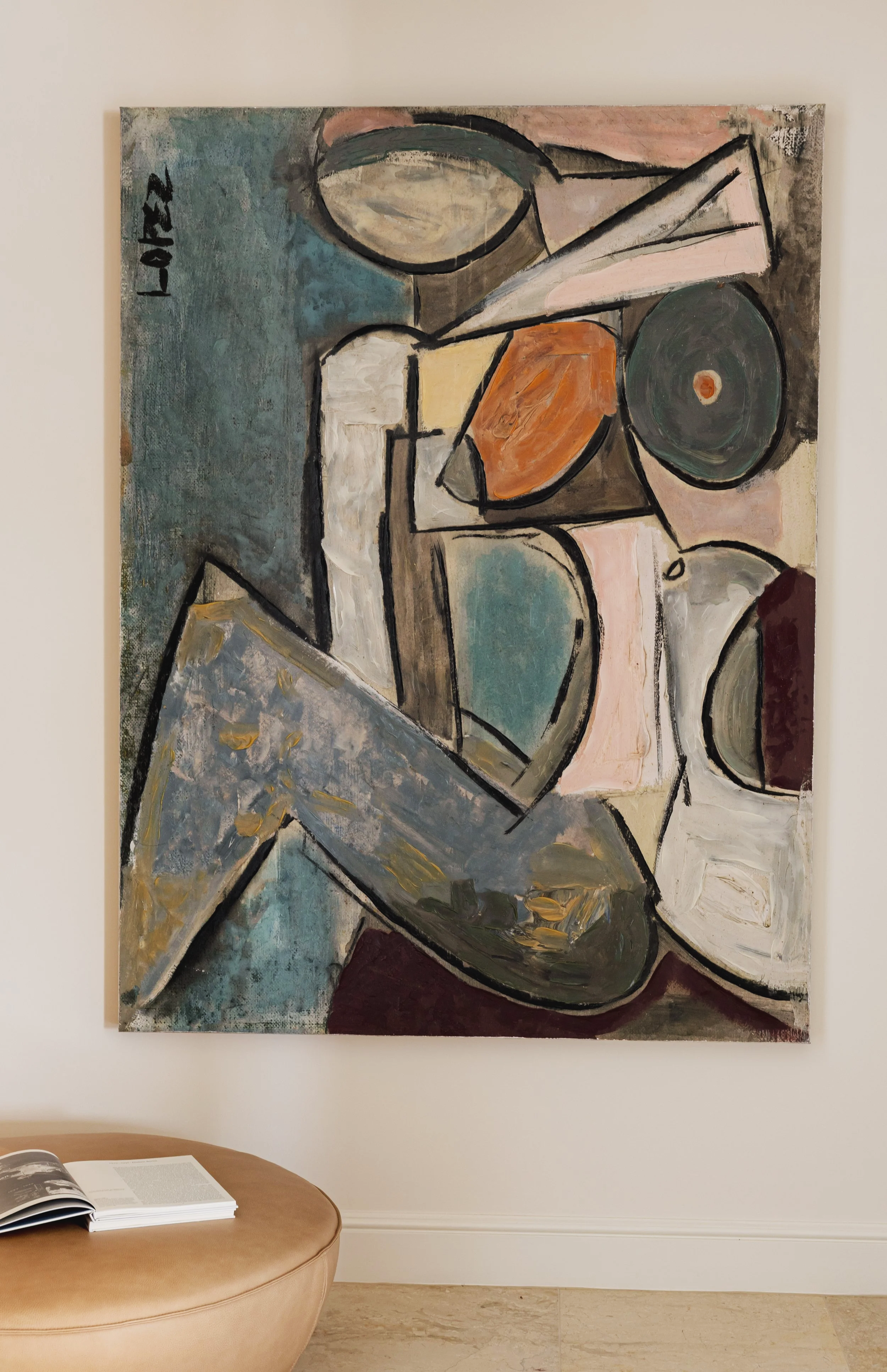 Living room with a cream-colored sectional sofa, a beige armchair, a wooden coffee table, a tall floor lamp, and a large abstract painting on the wall. Sunlight filters through sheer curtains.