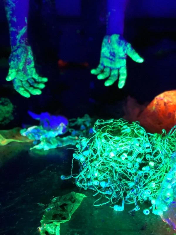 Manos y objetos fluorescentes en un entorno de luz UV