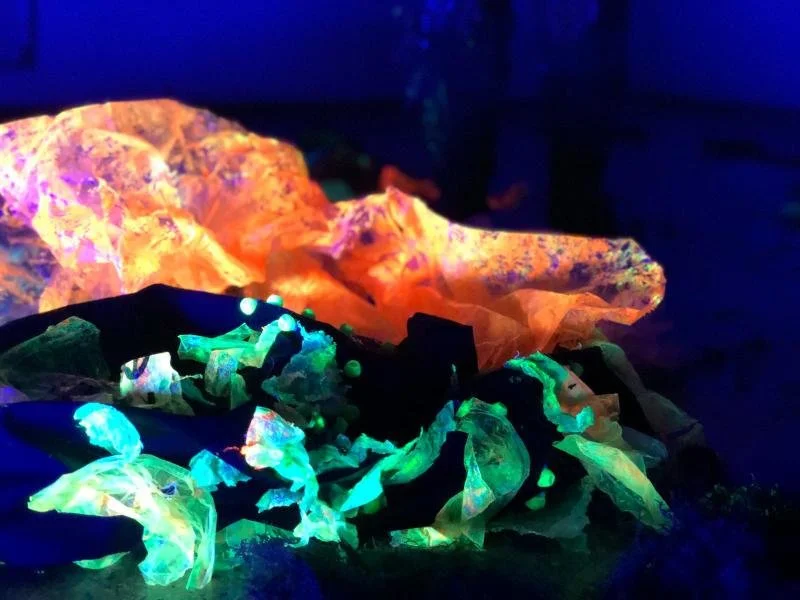 Papel translucido y plegado que brilla con colores fluorescentes bajo luz negra