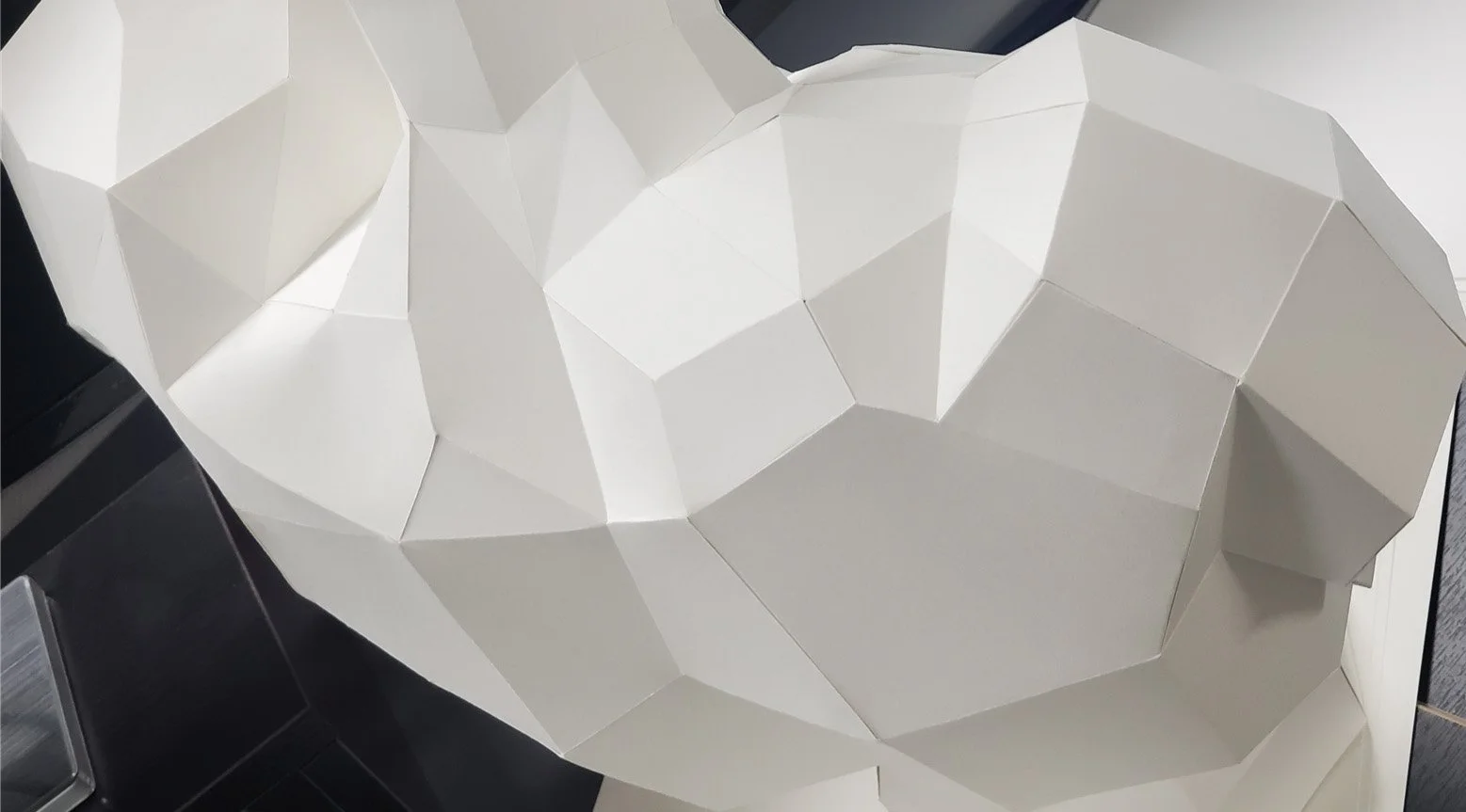 A precision-engineered paper sculpture by LUMISCA, showcasing how sharp edges function as connections between planes of light and shadow, embodying the philosophy of structural resilience.