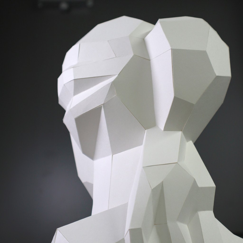 Studio shot of the LUMISCA Venus papercraft, highlighting the precise geometric structure where the deepest shadows support the brightest surfaces, rooted in over 35 years of expertise.