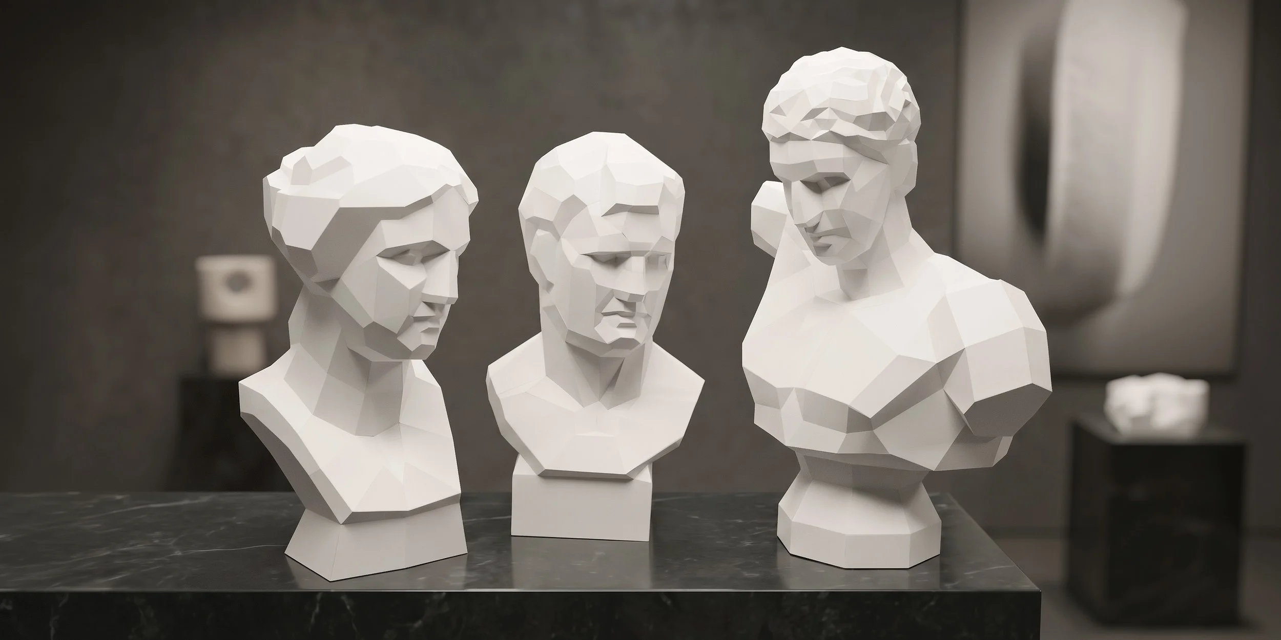 Three white paper sculptures (Venus, Agrippa, and Hermes) by LUMISCA displayed together on a dark marble counter. Highlighting sharp geometric facets and architectural shadows under warm lighting.