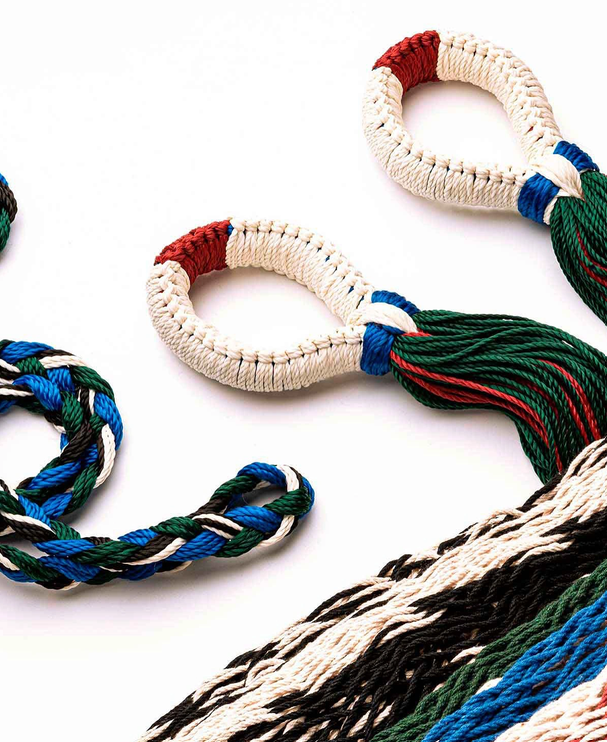 Close-up of various colorful woven nylon ropes and slings on a white background.