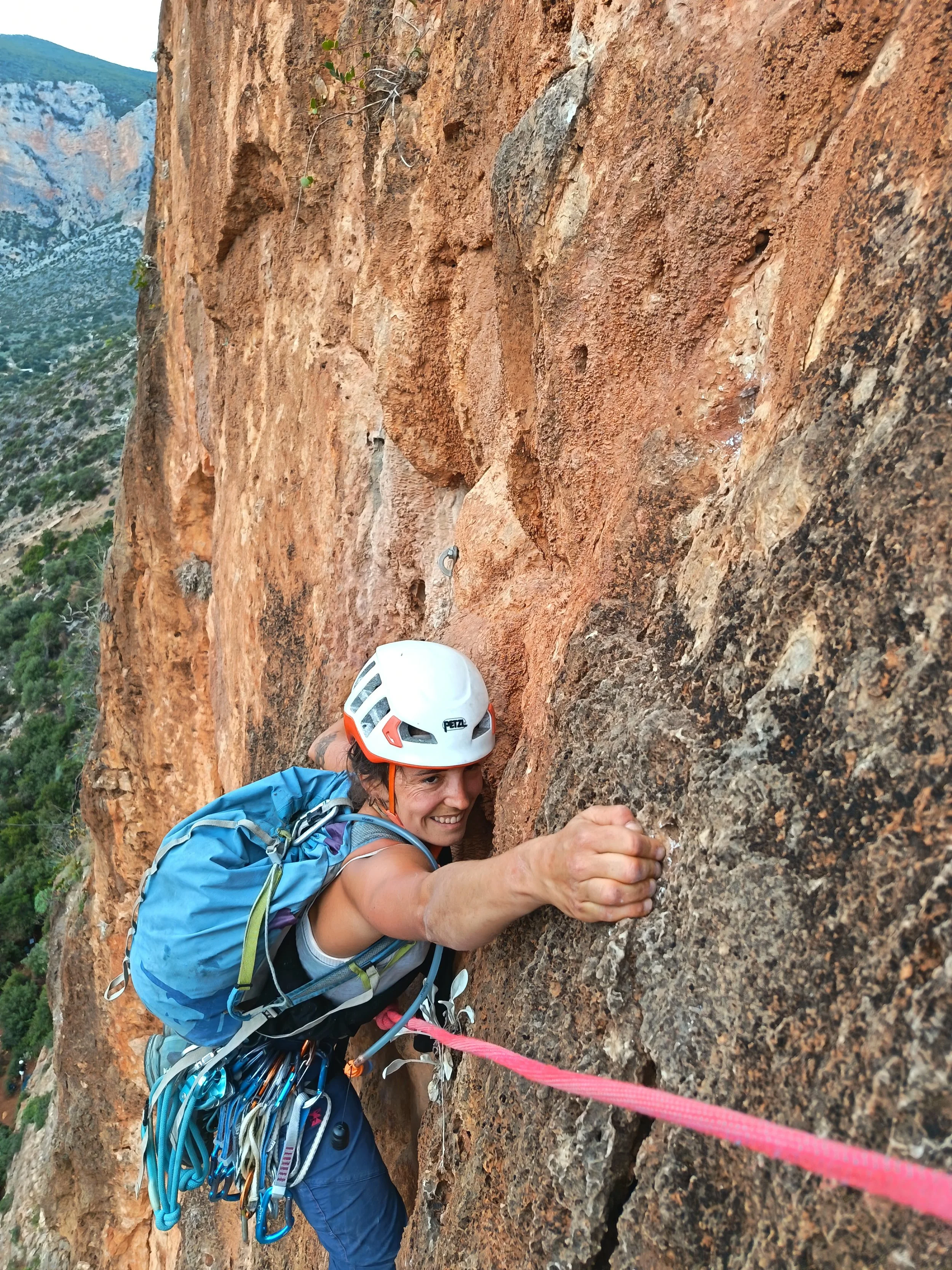Grimpeuse en pleine ascension sur roche orange