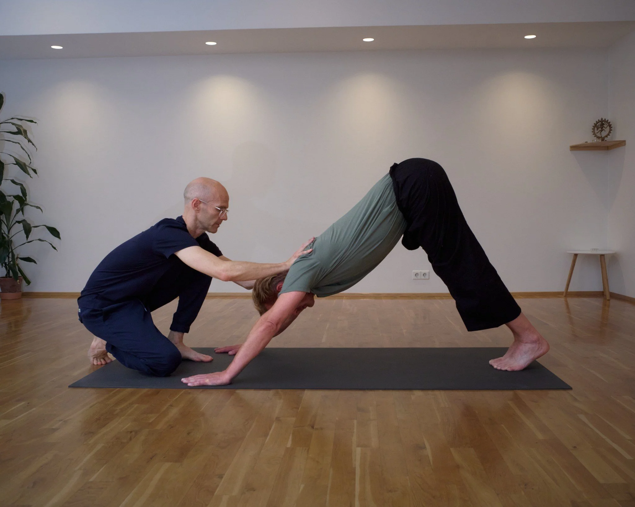 Gummi guiding a student in an individual yoga practice at Art of Yoga