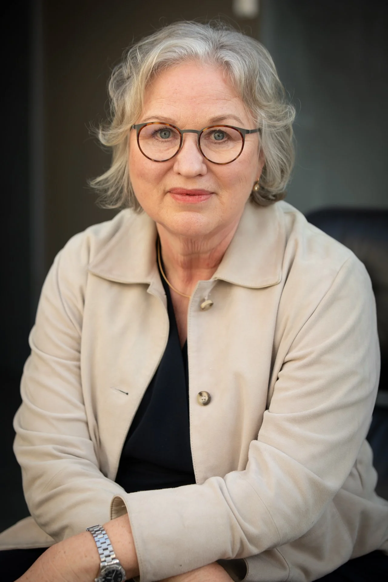 Dr. med. Henrike Schwarz, psychodynamische Business Coachin, Porträt mit verschränkten Armen in ruhiger Umgebung
