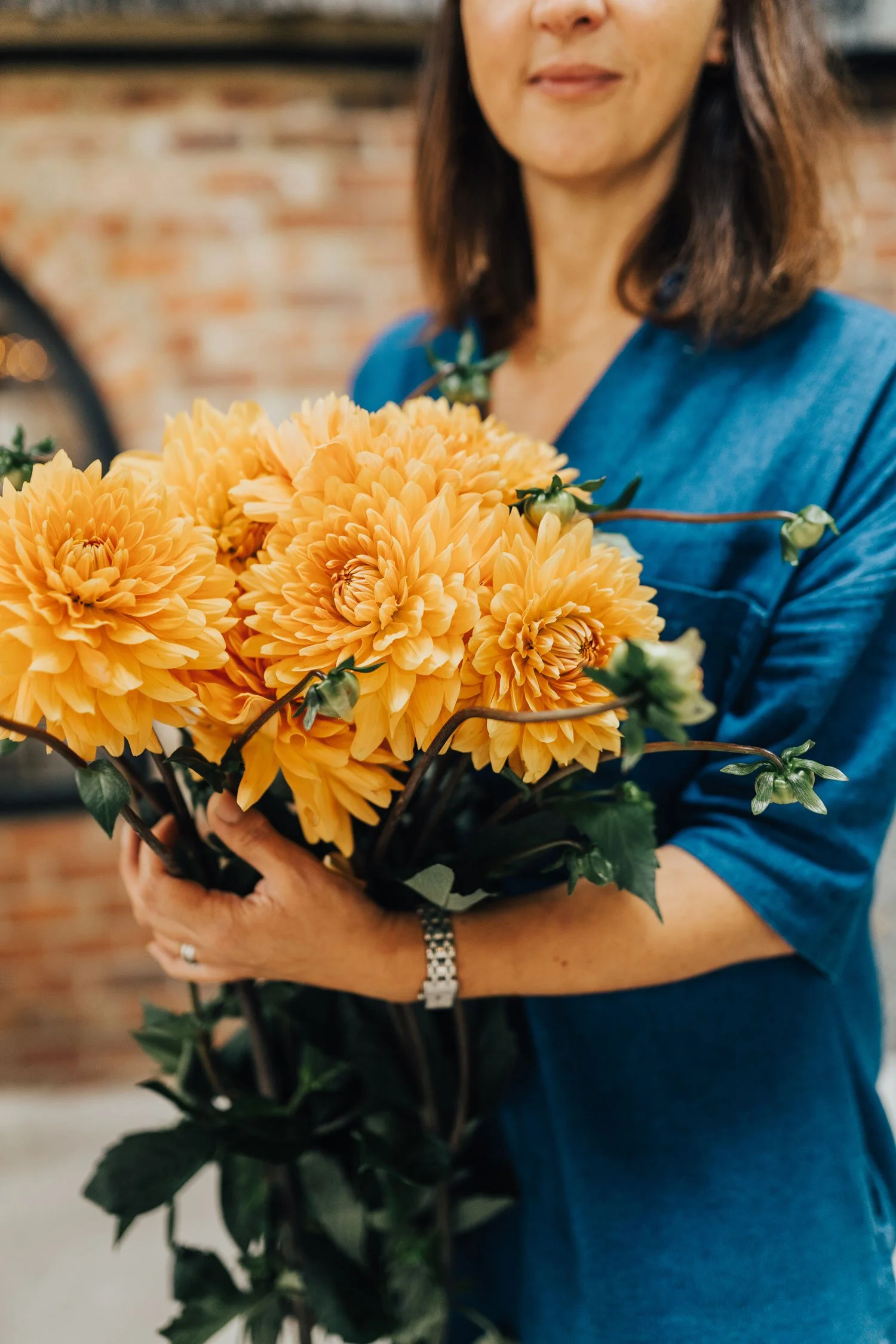 South East wedding florist holding orange wedding bouquet