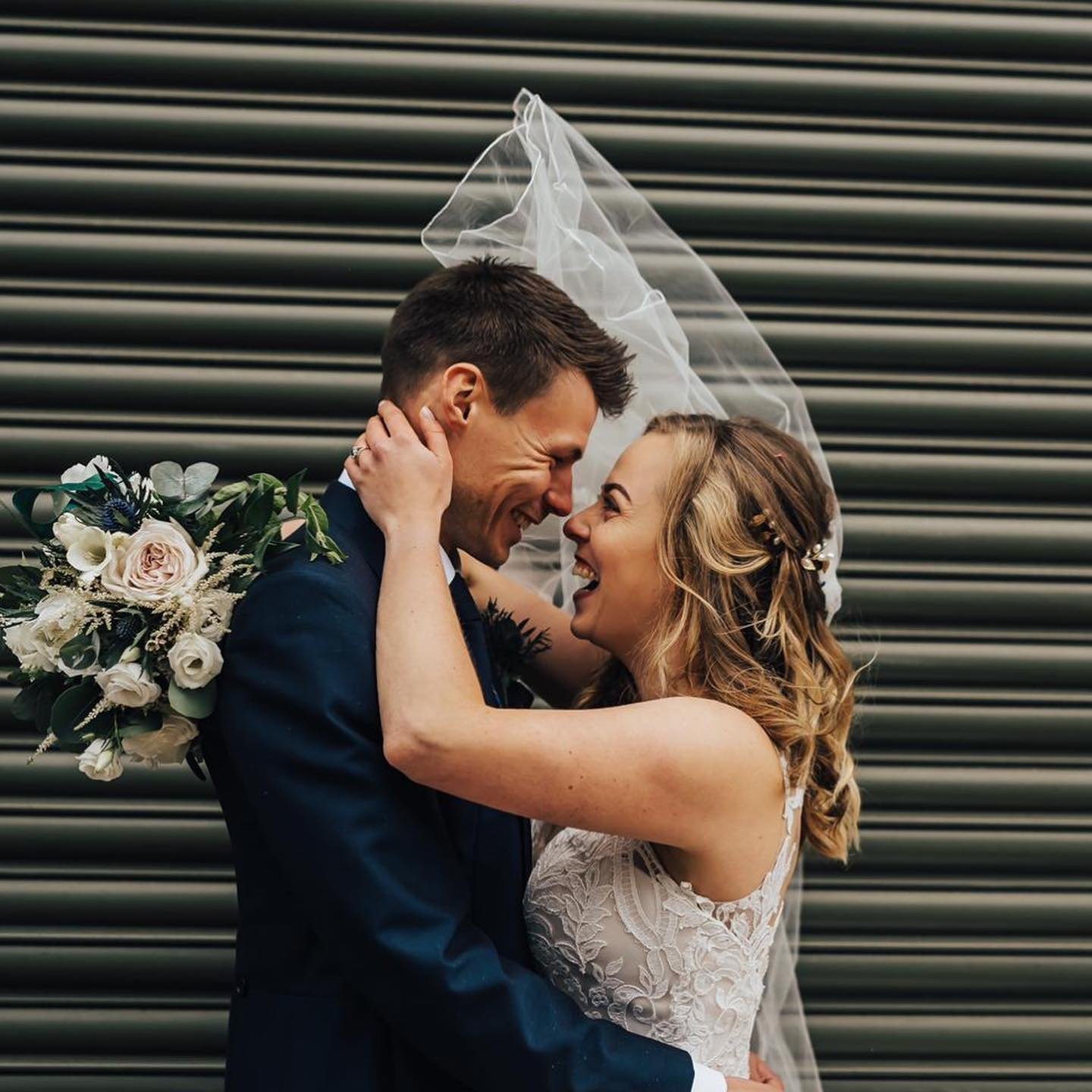 Kent bride and groom hugging holding bridal bouquet of flowers