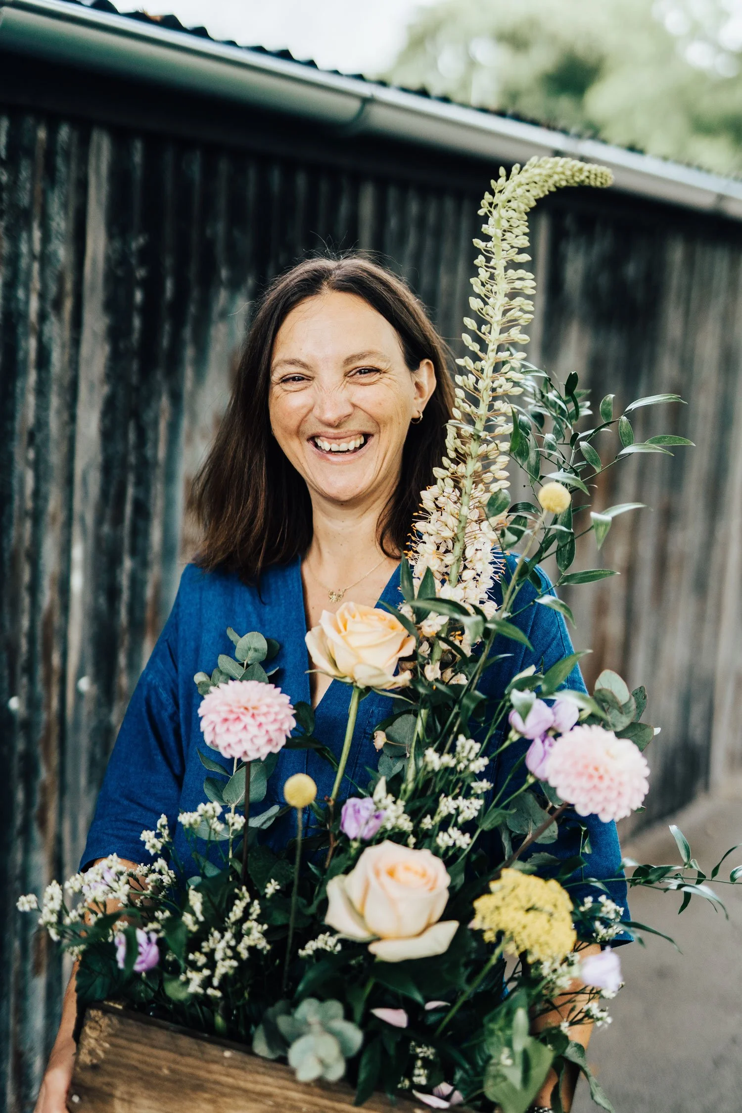 London and Kent based florist Jo stood in garden holding beautiful floral arrangement