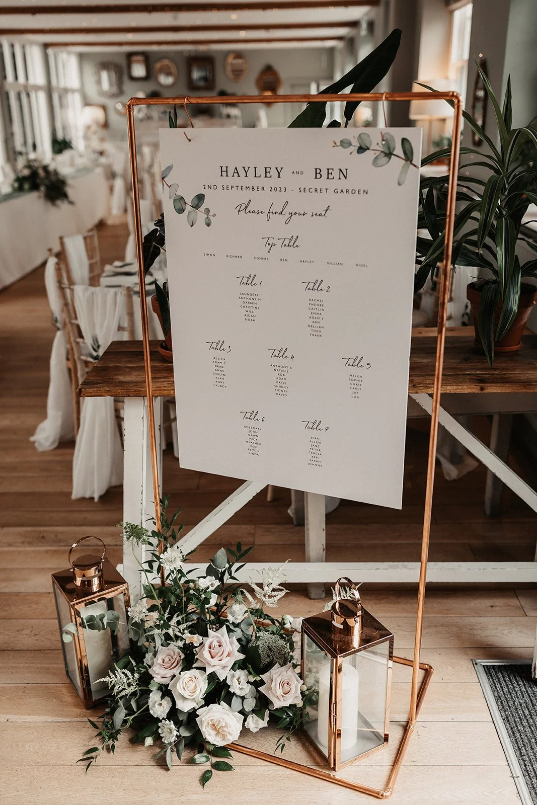 moody-blooms-wedding-seating-plan-floral-display-roses-lanterns.jpg