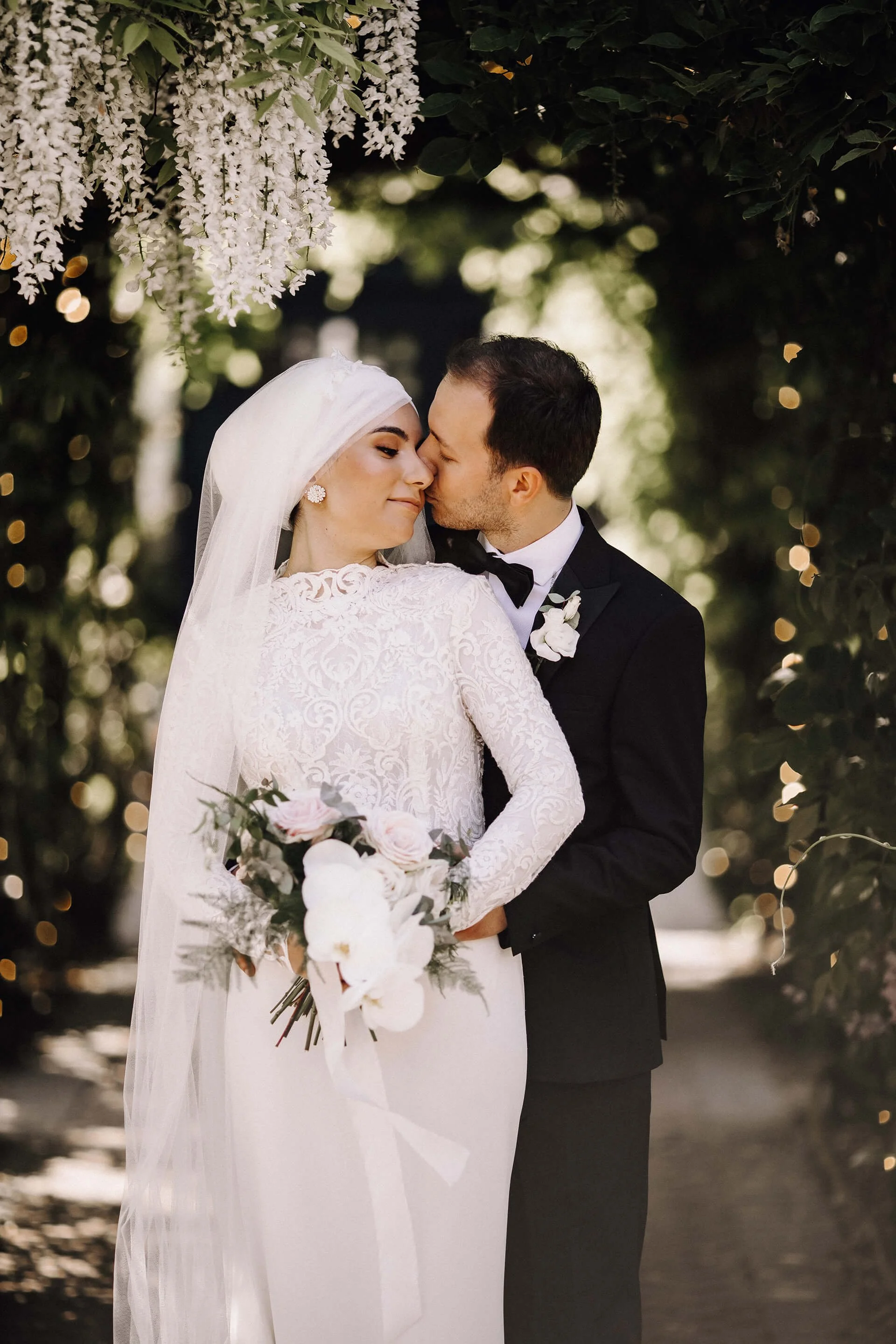 moody-blooms-wedding-couple-wisteria-arch-orchid-bouquet-wedding-florist.jpg