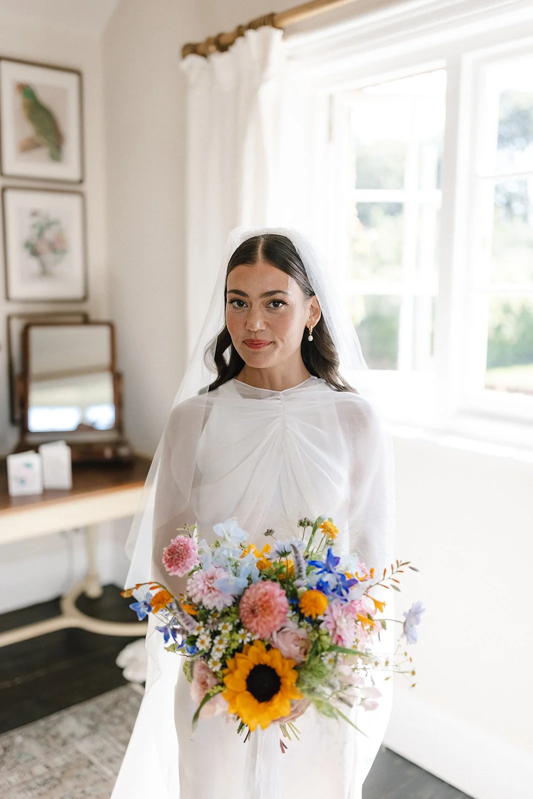 Bride holding sunflower and wildflower wedding bouquet