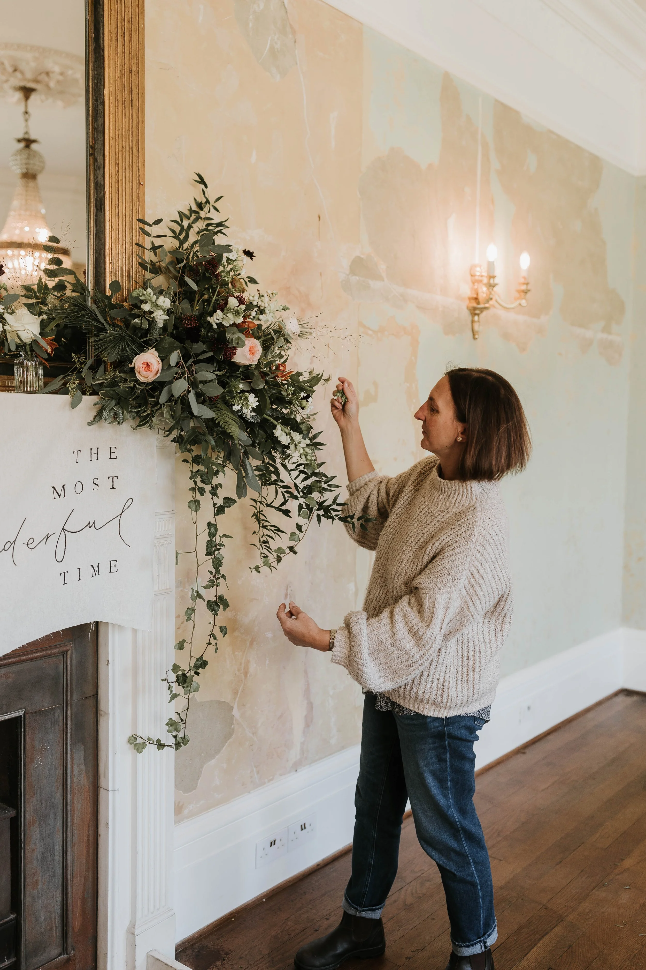 London based florist adjusting floral installation at wedding
