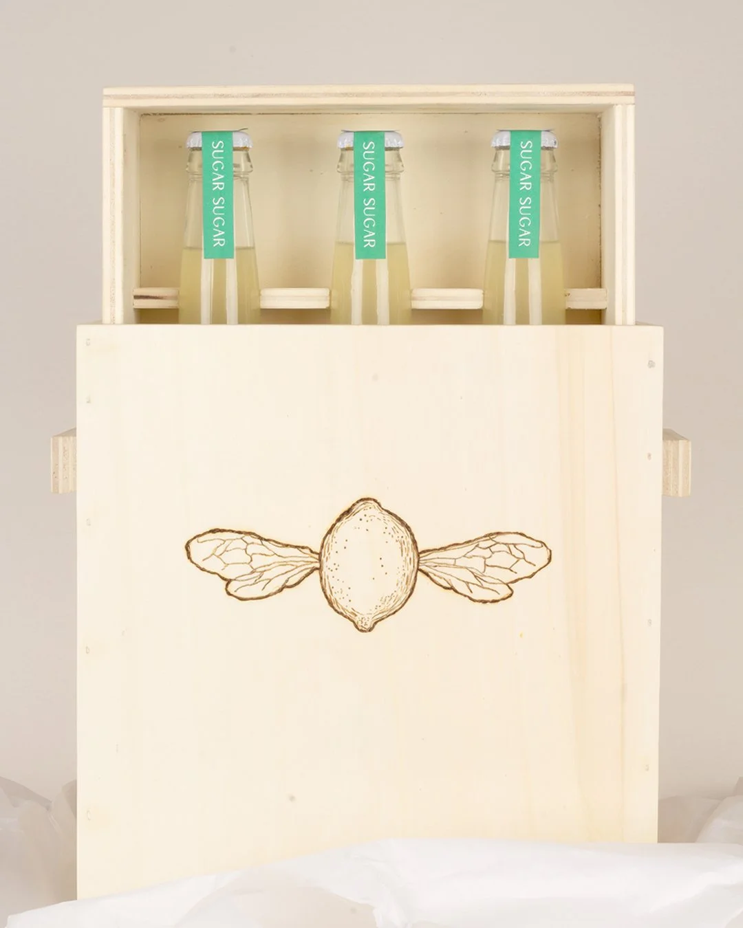 lemonade packaging with minimal label design, delicate line illustrations and subtle gold foil bee wing details, styled with soft, natural photography