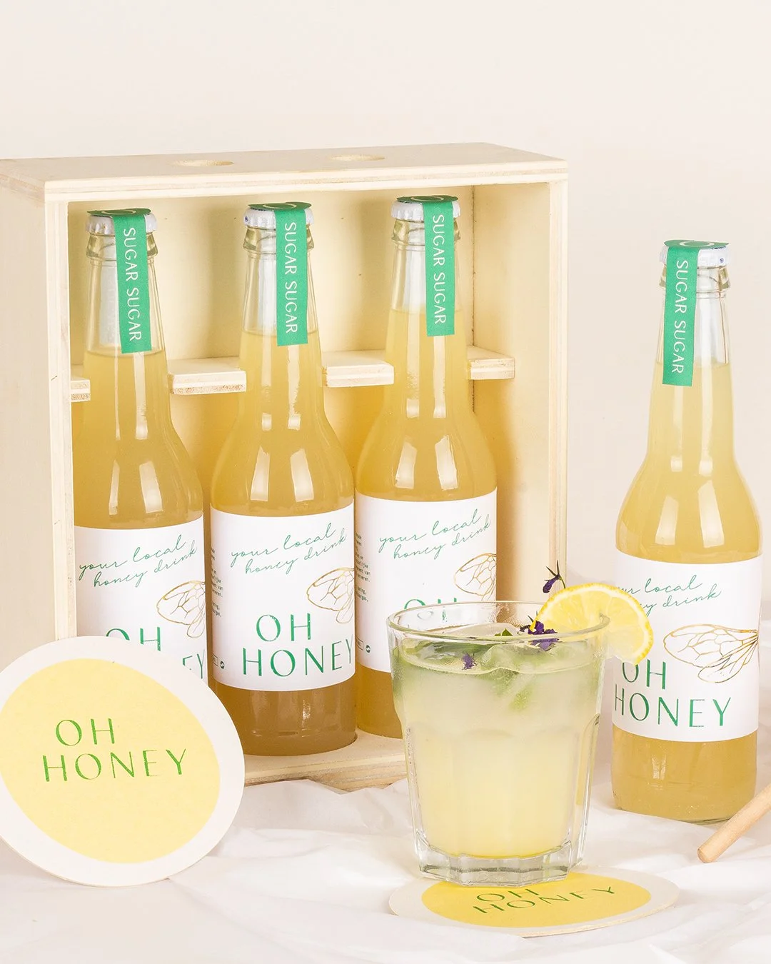 lemonade packaging with minimal label design, delicate line illustrations and subtle gold foil bee wing details, styled with soft, natural photography