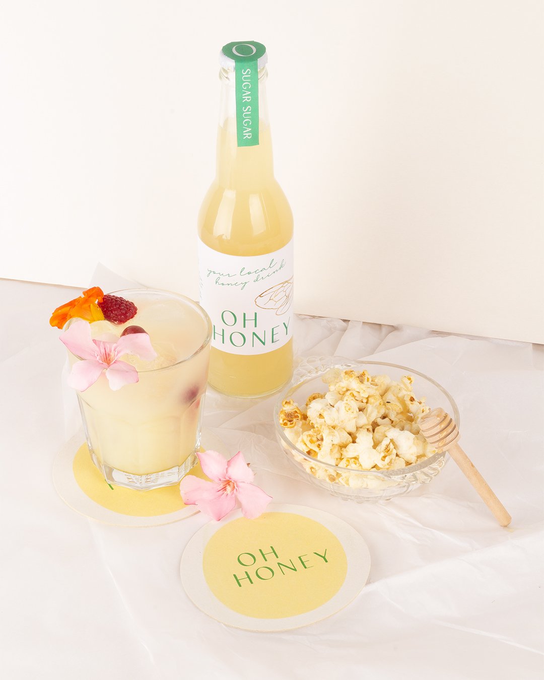 lemonade packaging with minimal label design, delicate line illustrations and subtle gold foil bee wing details, styled with soft, natural photography