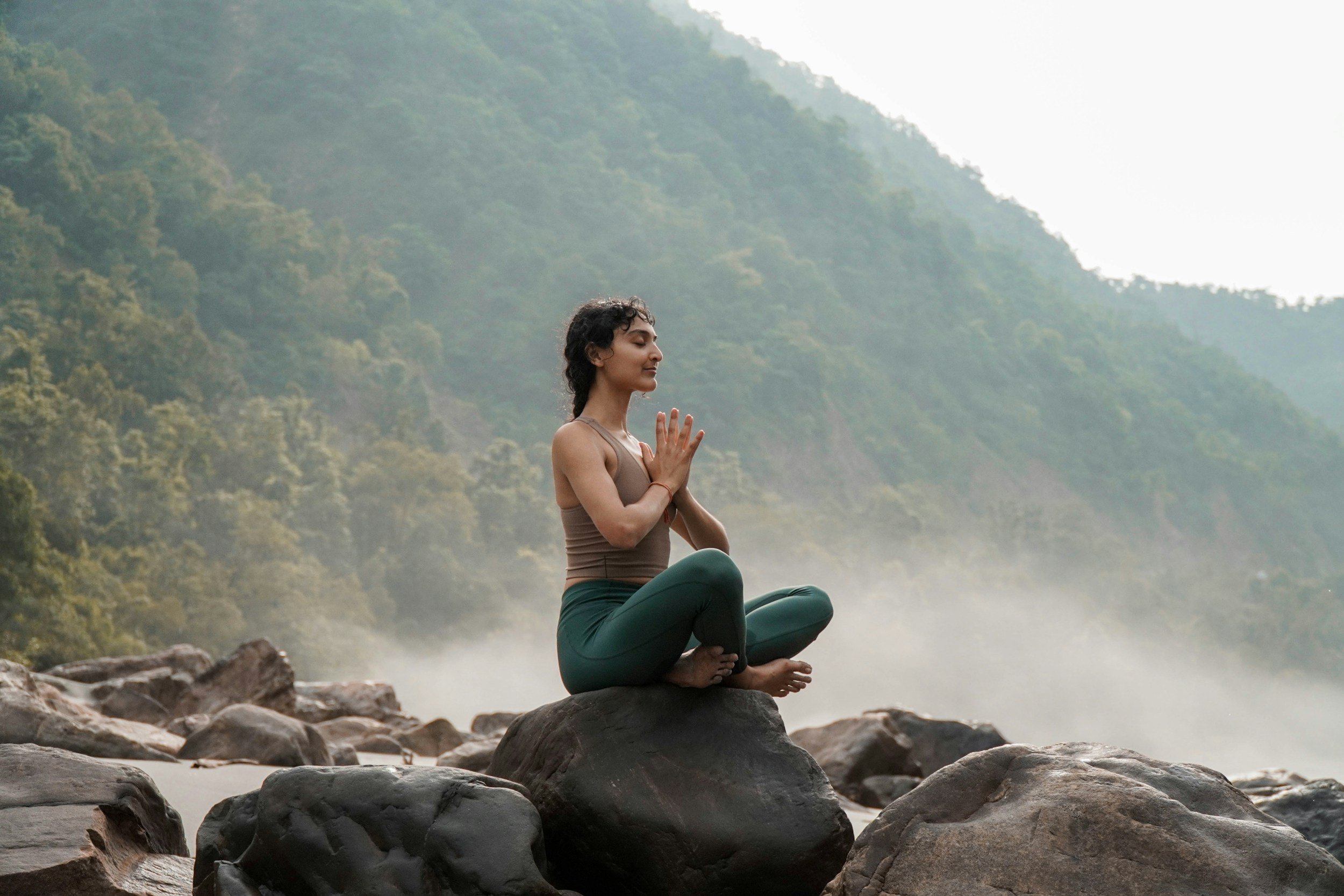 Woman meditating in nature to support calm, focus and self-awareness.