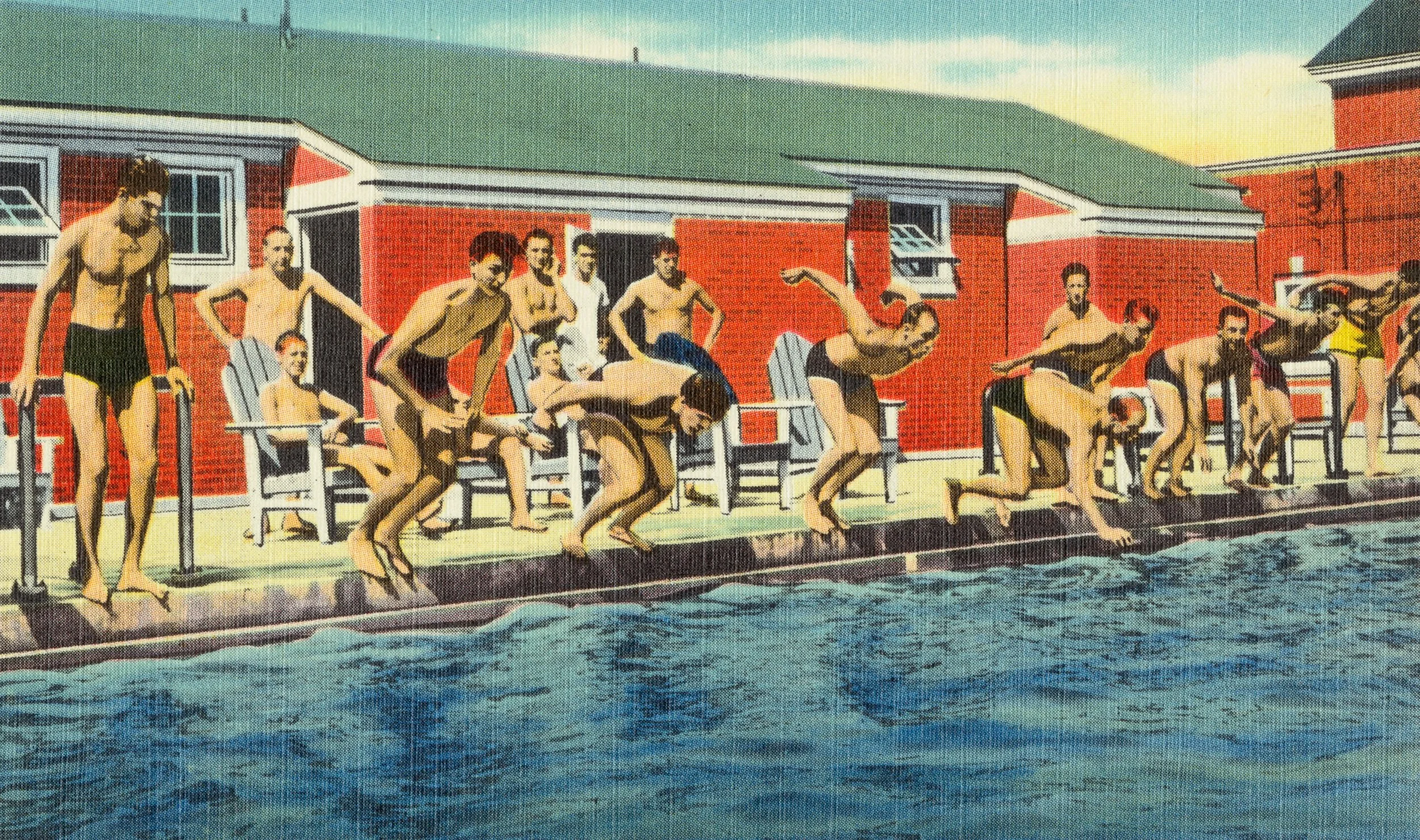 A vintage color photograph of people in swimsuits at an outdoor swimming pool, some sitting on chairs, some jumping into the water, with a building with a red brick wall in the background and a green roof.