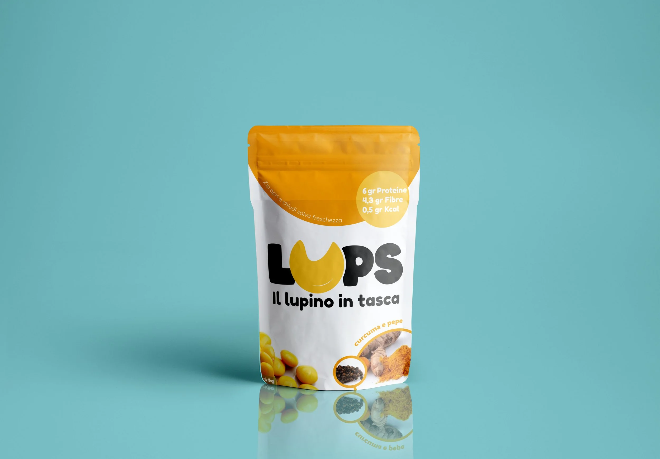 A standing packet of food with a yellow and white design, containing chickpeas, turmeric, and pepper, against a teal background.