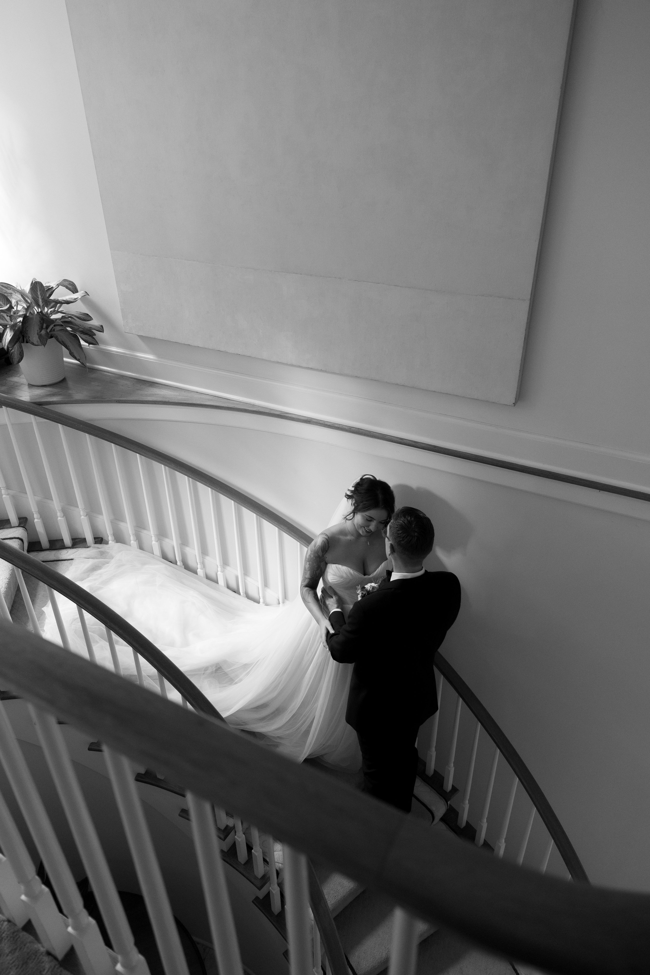 A bride and groom on a staircase during their wedding, sharing a moment together.