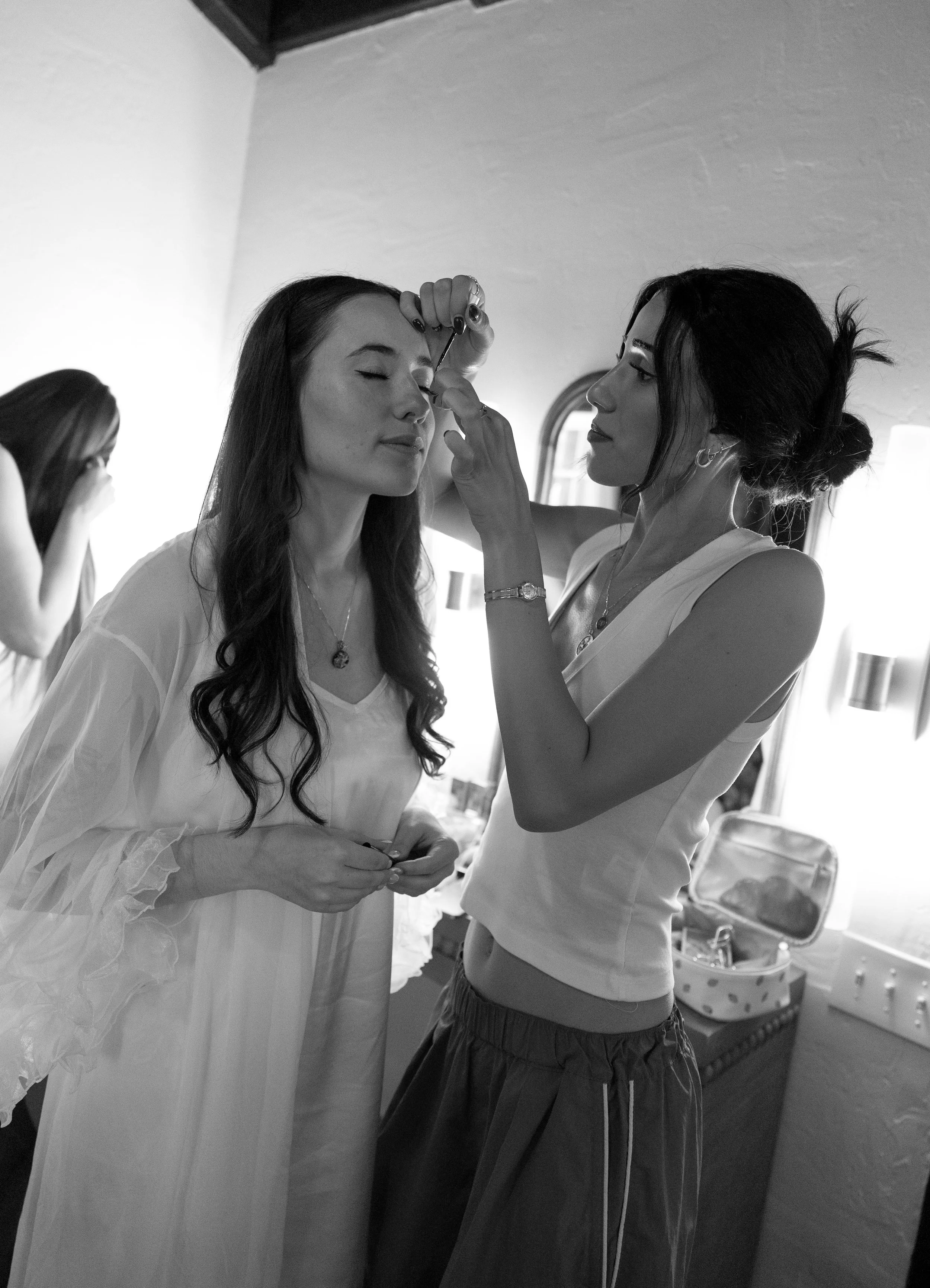 A bride getting her makeup done in a room with natural light, while getting ready for her ceremony at a Rancho Las Lomas Wedding in Los Angeles