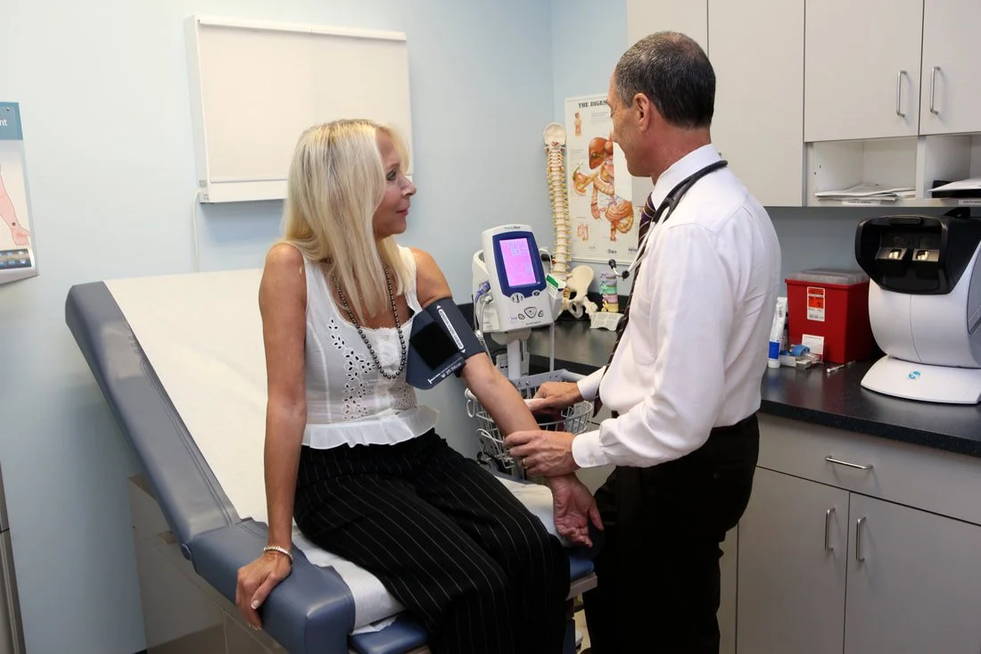Doctor consulting with a patient in a medical office using diagnostic equipment