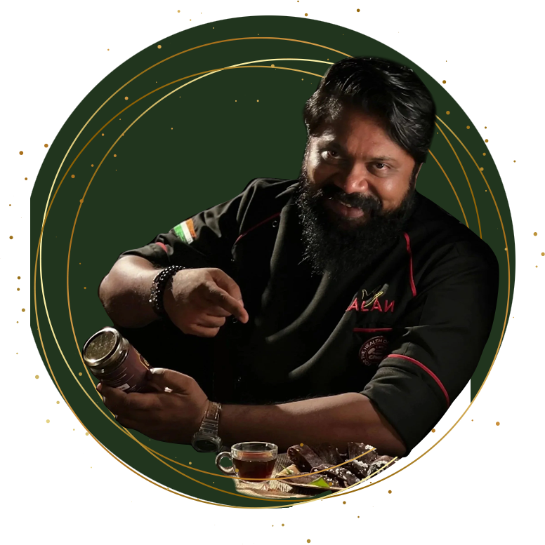 A man with a beard and mustache, wearing a black chef's coat with red piping and an Indian flag patch, holding a jar of spices and pointing at it, with a cup of tea and some food on the table in front of him, against a dark background with gold decorative elements.