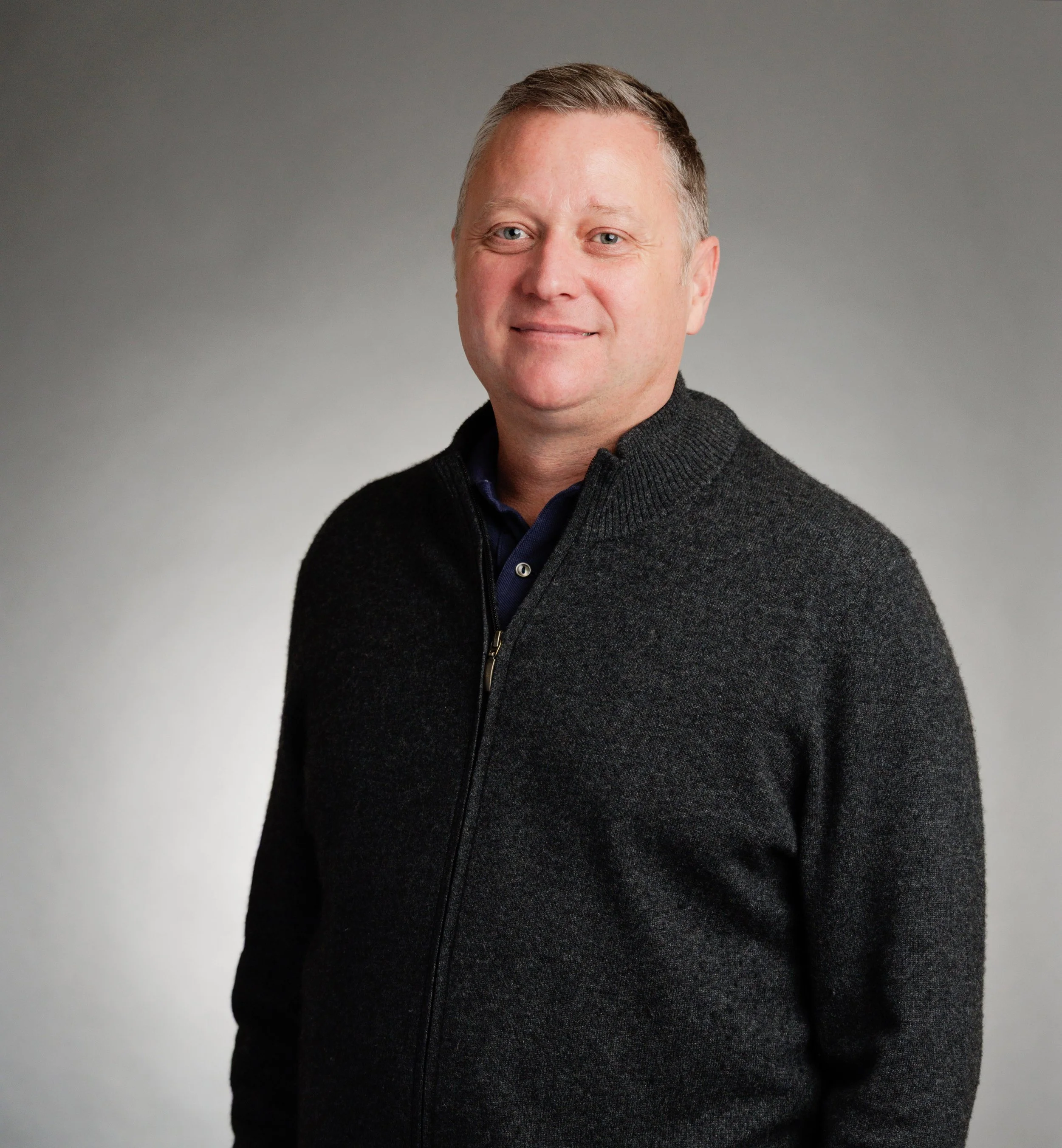 Wide shot of Peter Munro, LCSW with a casual smile in a dark grey sweater