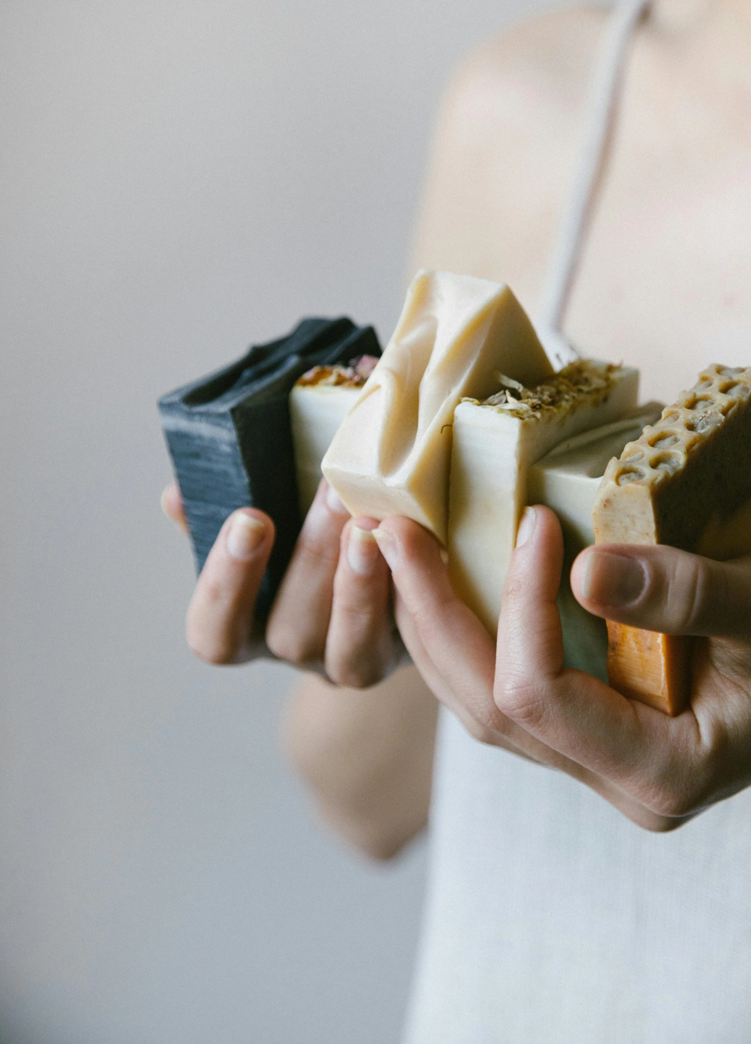 hands holing natural handmade soaps used in brand identity design for a handmade wellness soap brand
