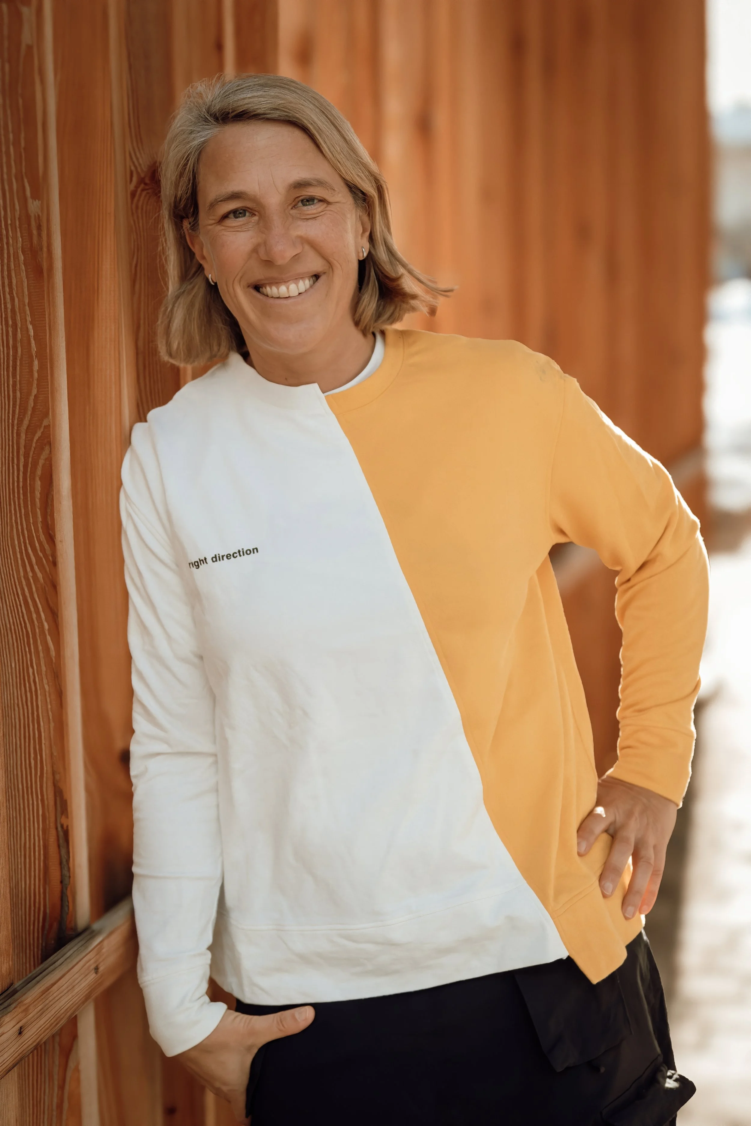 Sara Montagnolli, Initiatorin von 35by32, lächelt vor einer Holzwand