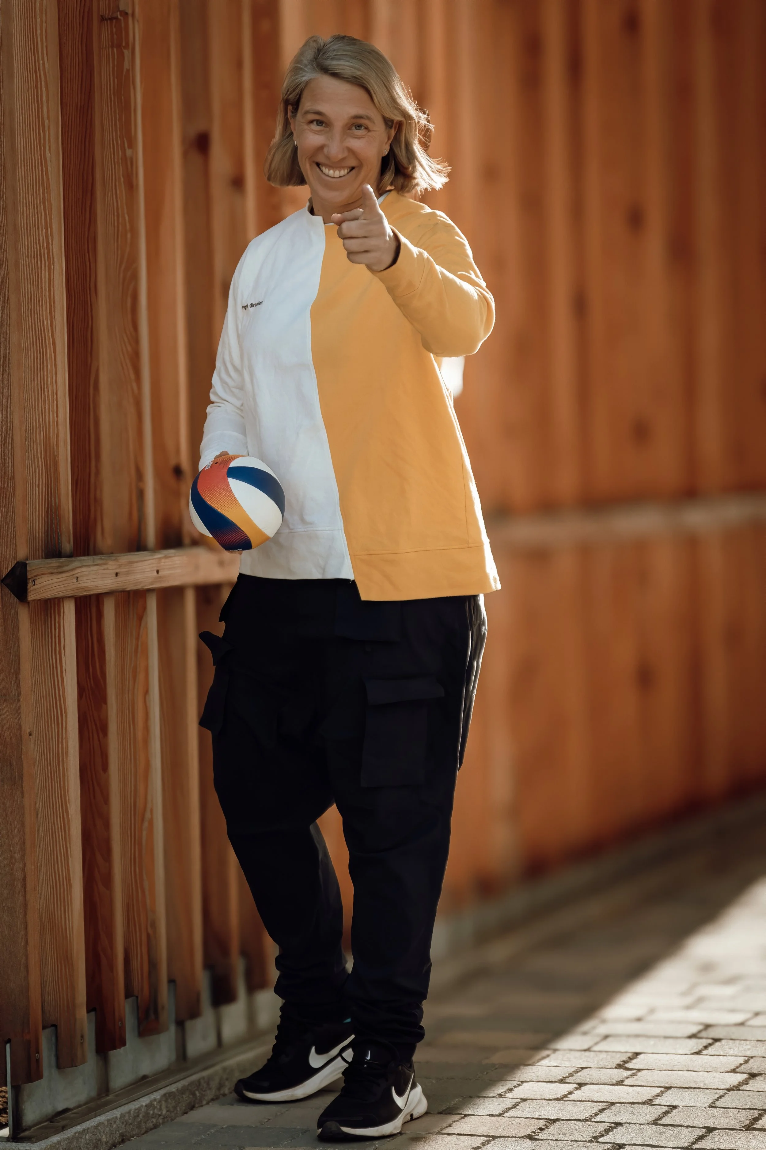 Sara Montagnolli, Initiatorin von 35by32, mit Volleyball vor einer Holzwand