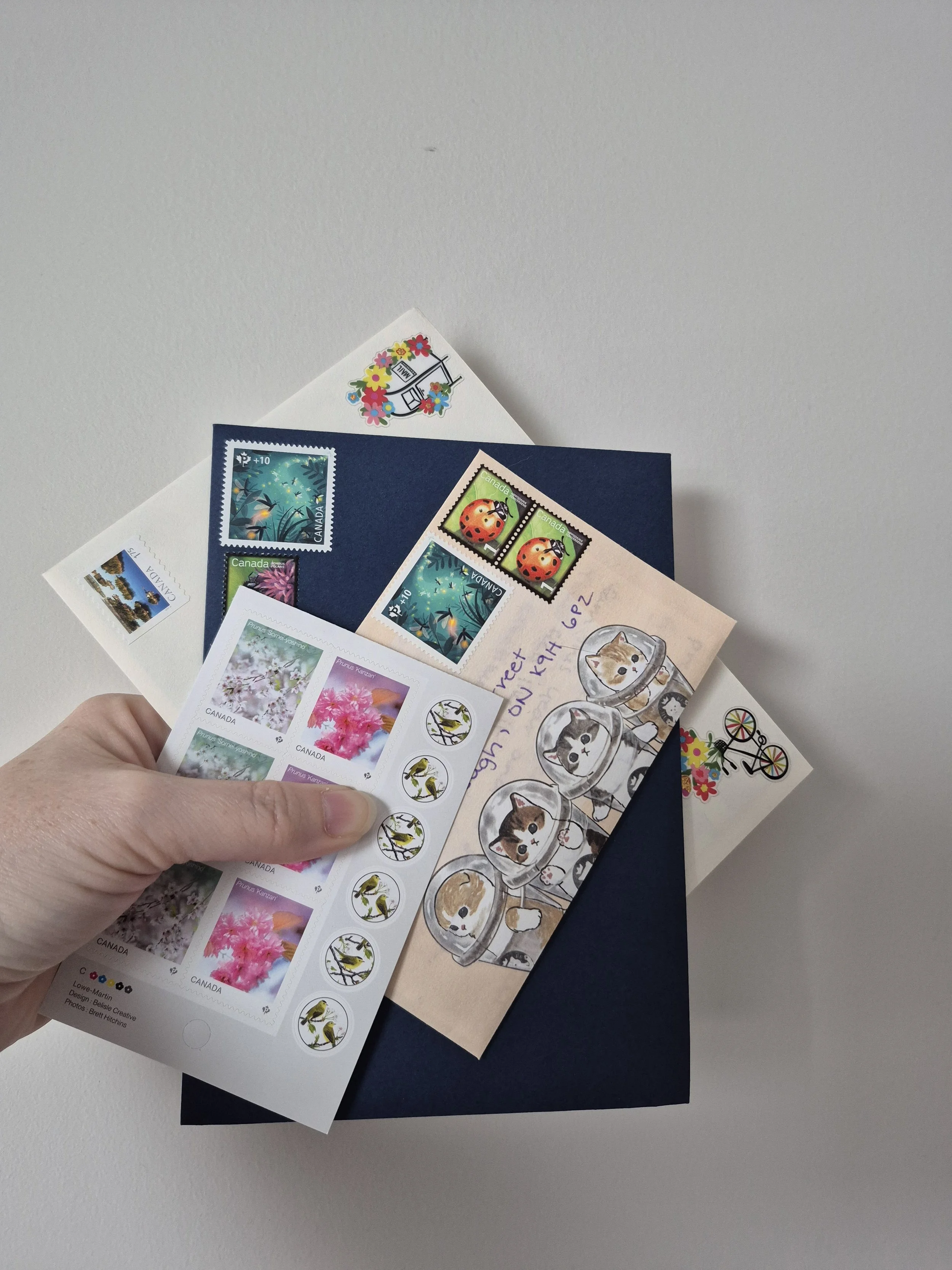 Collection of colorful postage stamps, postcards, and greeting cards with floral and animal illustrations on a white background.