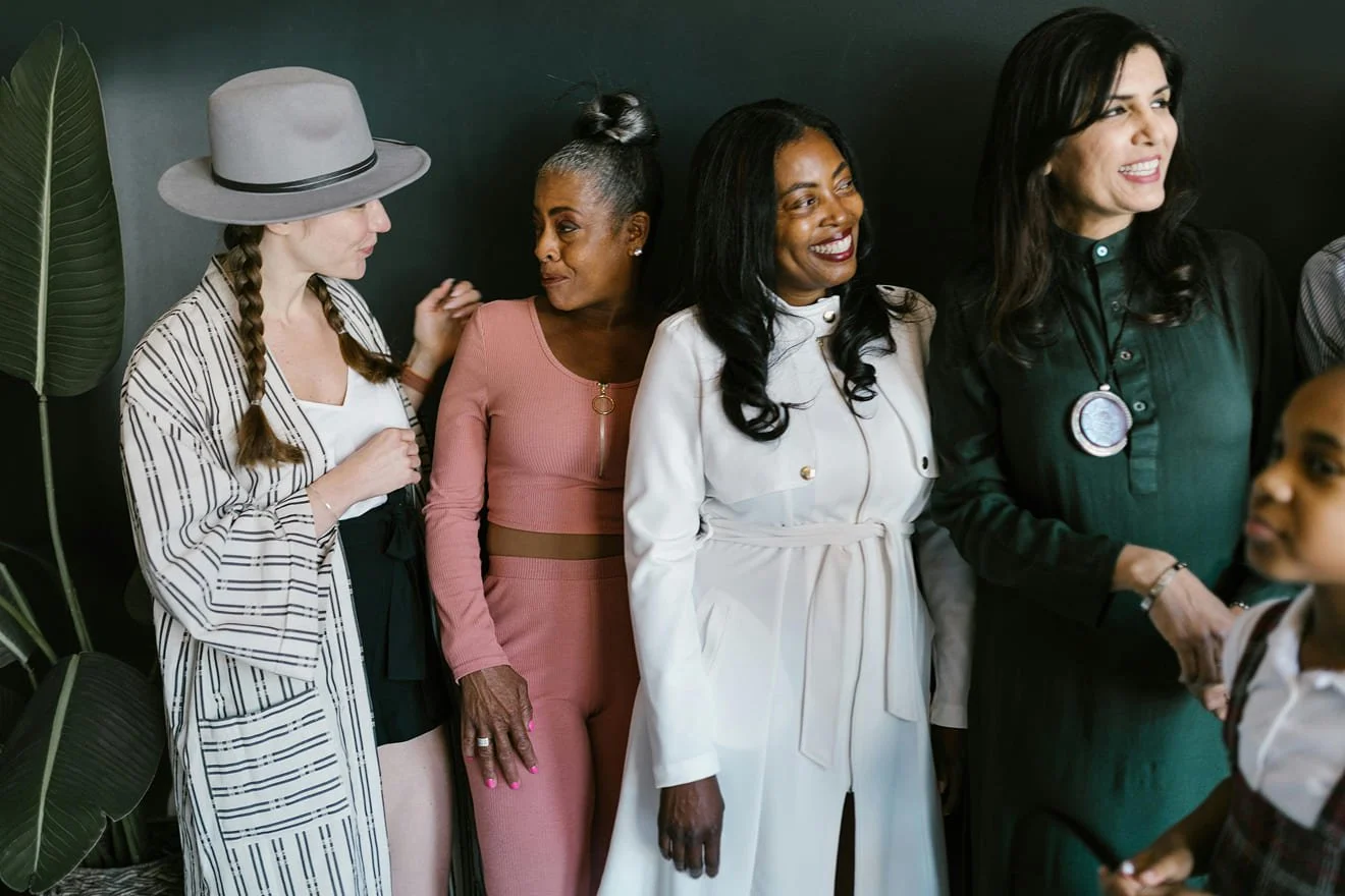 Group of diverse women engaging in conversation in an indoor setting.