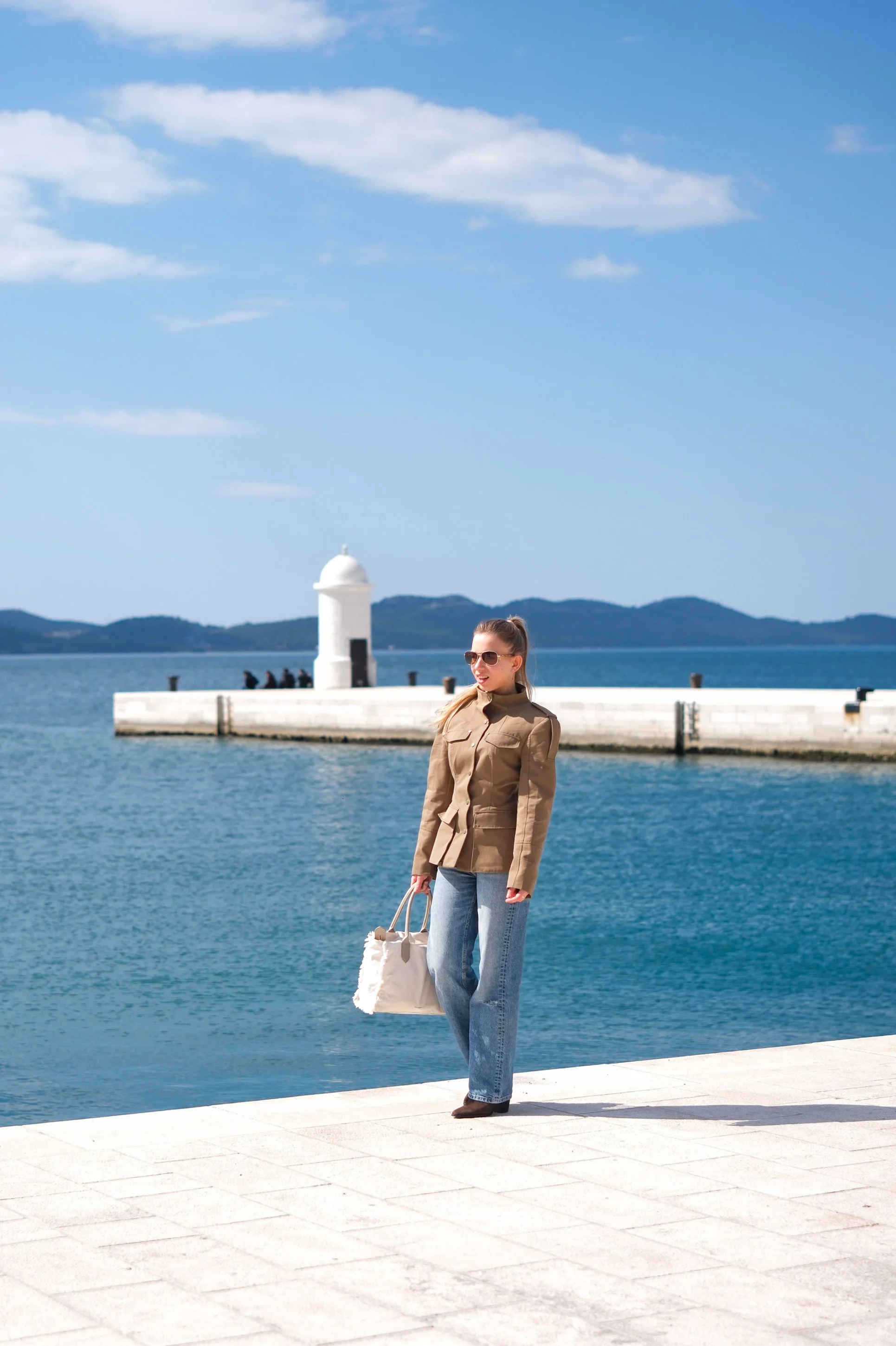 A relaxed solo travel photoshoot by the sea in Zadar, Croatia. Natural light, clean composition, and candid walking moments create timeless vacation photos. Perfect inspiration for solo travelers looking for effortless and elegant travel photography.