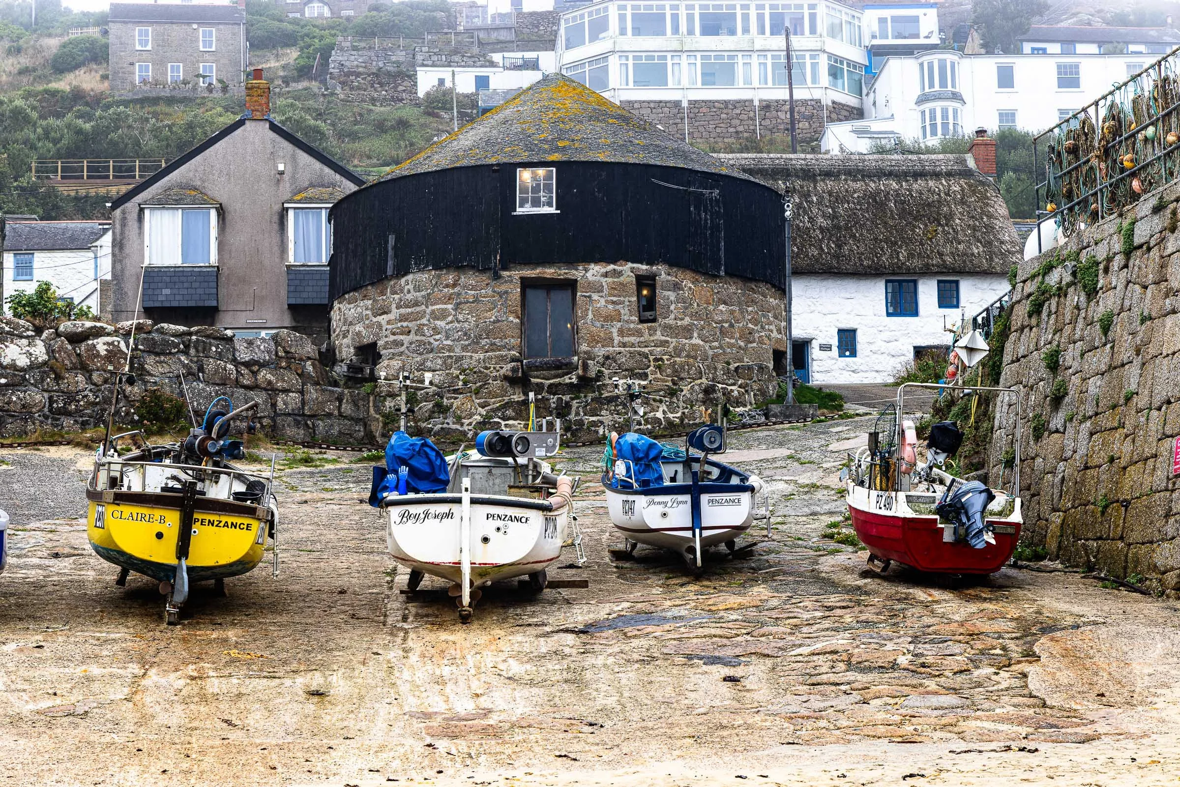 Traditional fishing boats on the slipway outside the historic stone Roundhouse at Sennen Cove Cornwall, fine art canvas by Lowena Studios