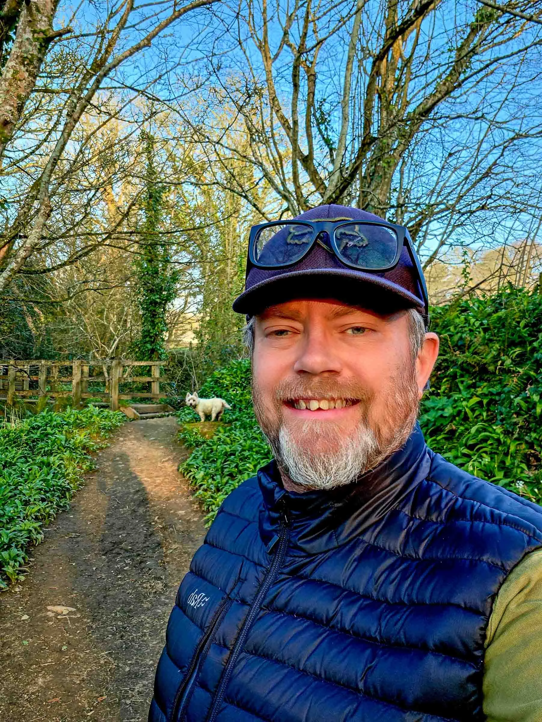 Image of the founder of Lowena Studios in the woods near the Cornish coast with his Westie