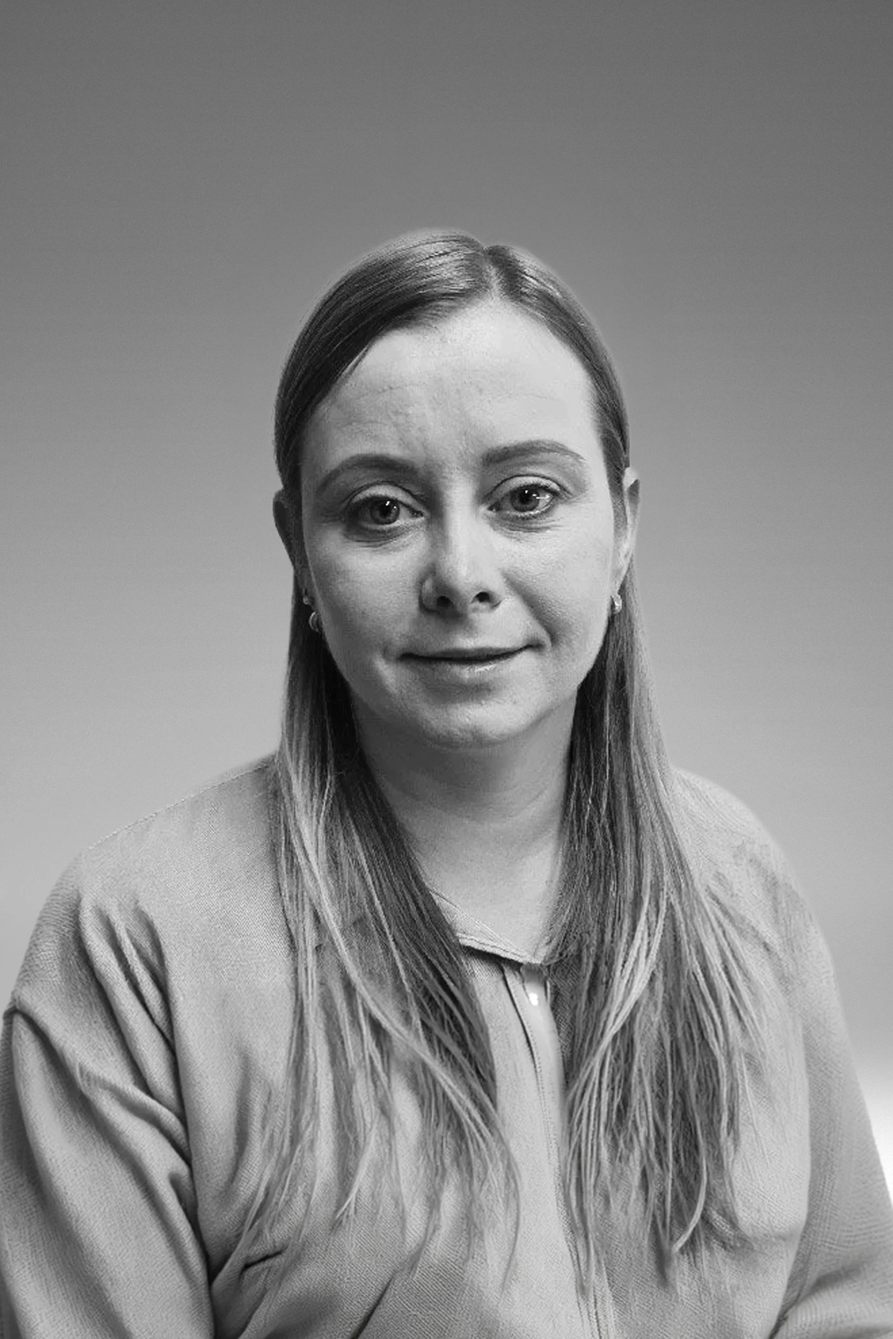 Black and white portrait of a woman with long hair, wearing a textured top, looking directly at the camera.