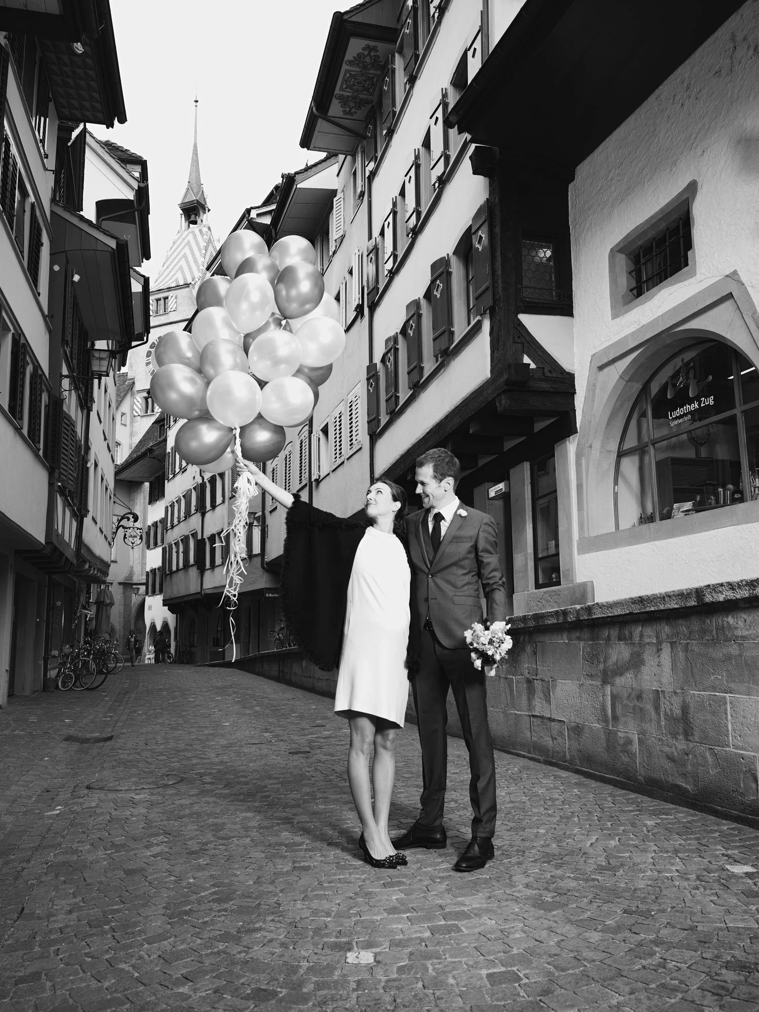 Happy wedding couple with balloons in the historic old town of Zug, Switzerland