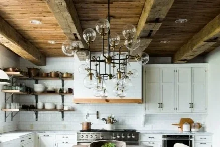 Kitchen with white cabinets and open wooden shelves, stainless steel stove, and a glass globe chandelier hanging from a wooden ceiling.
