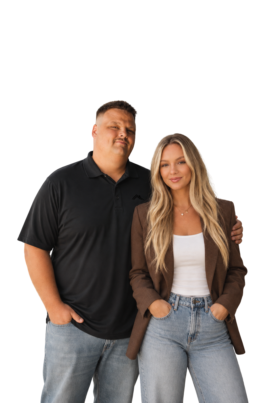 A man and woman standing close together, both with confident expressions. The man is wearing a black polo shirt and light blue jeans, while the woman is wearing a brown blazer, white tank top, and light blue jeans, with her hands in her pockets.