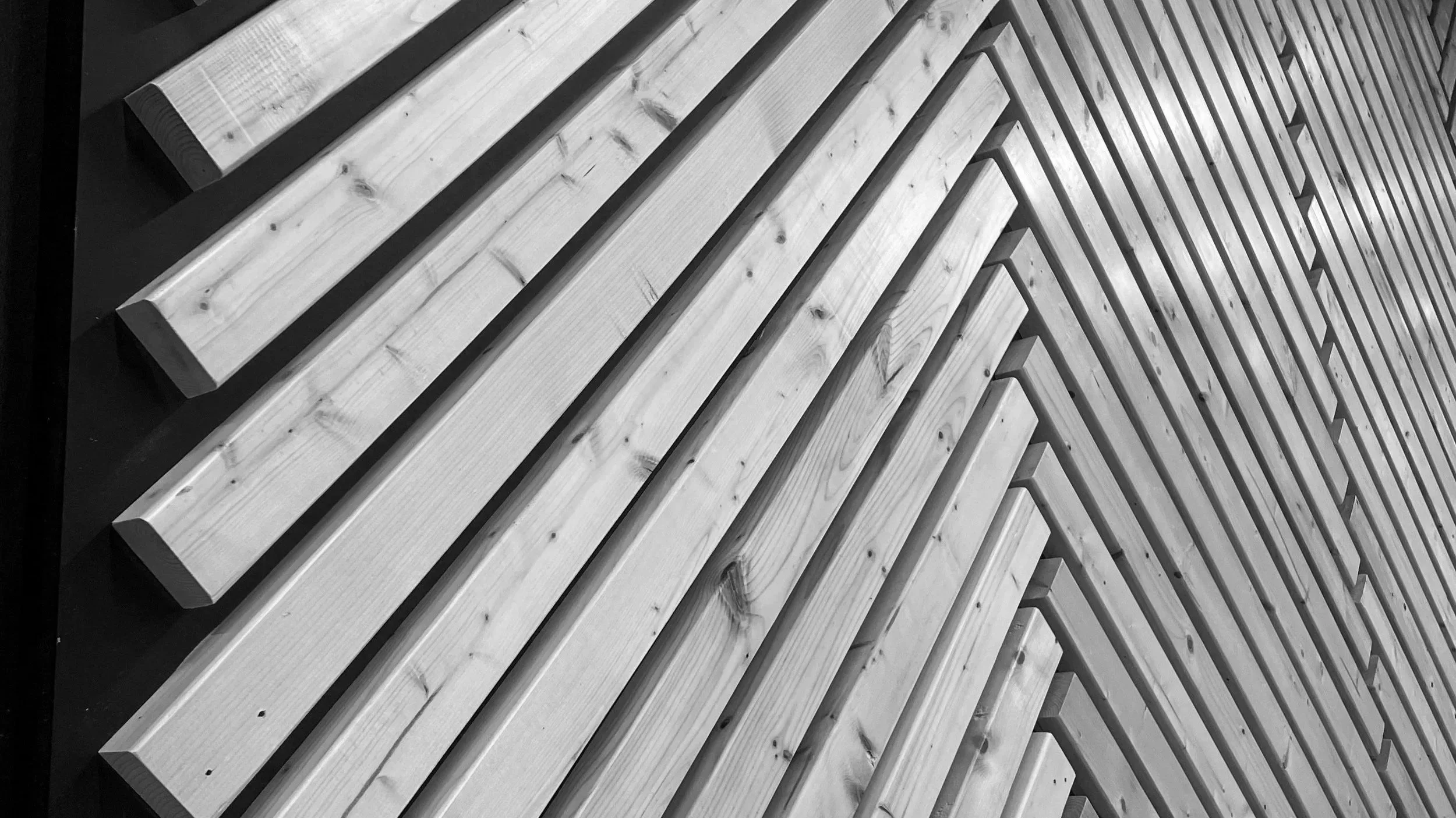 A pattern of wooden planks arranged in a geometric design on a dark surface.