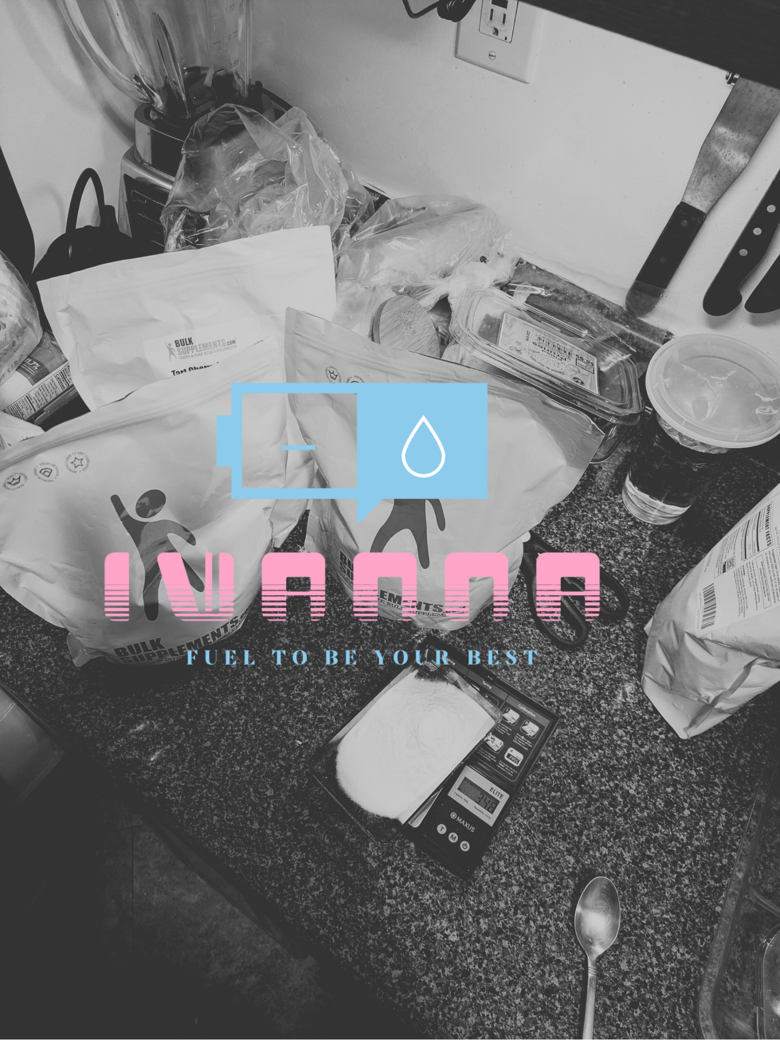 A cluttered kitchen counter with food packages, a digital kitchen scale, a spoon, and kitchen knives on a magnetic strip, in black and white.