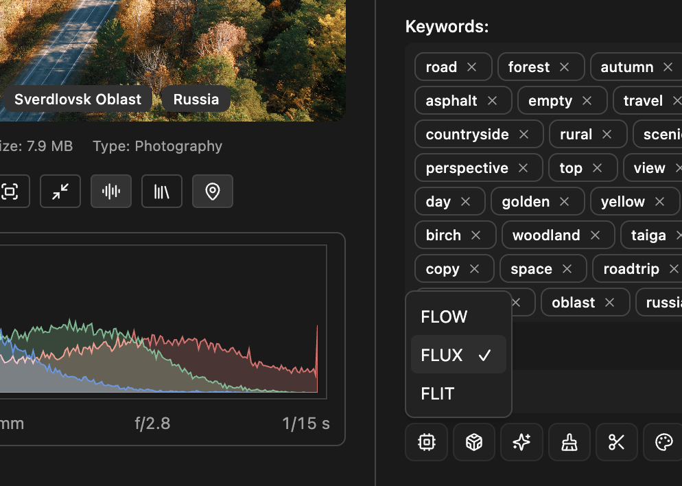 Aerial view of a rural highway cutting through a forest with autumn foliage, under a clear sky.